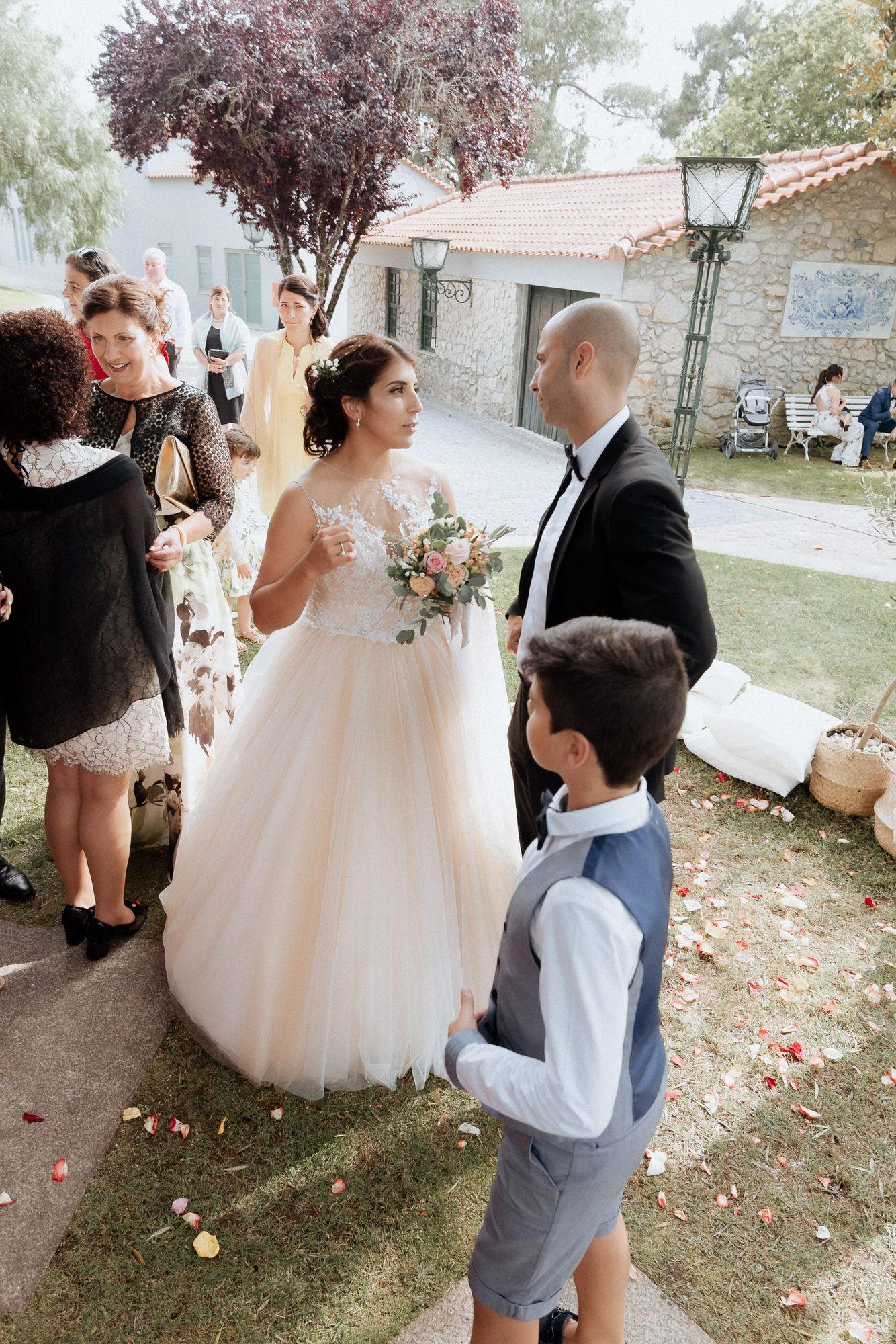 Wedding celebration in an outdoor garden setting with guests gathered around on a lovely afternoon.