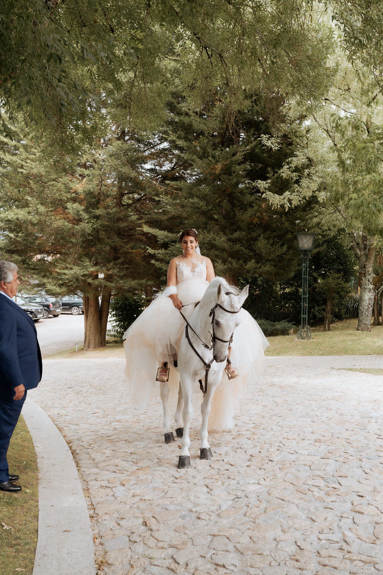 An elegant wedding ceremony setting in a wooded area with a majestic white horse on a snowy winter day.