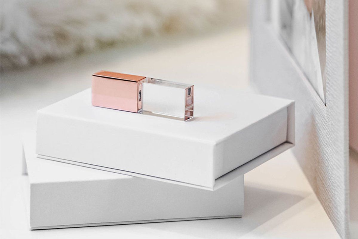 Egy kristály pendrive fehér díszdobozok tetején elhelyezve.