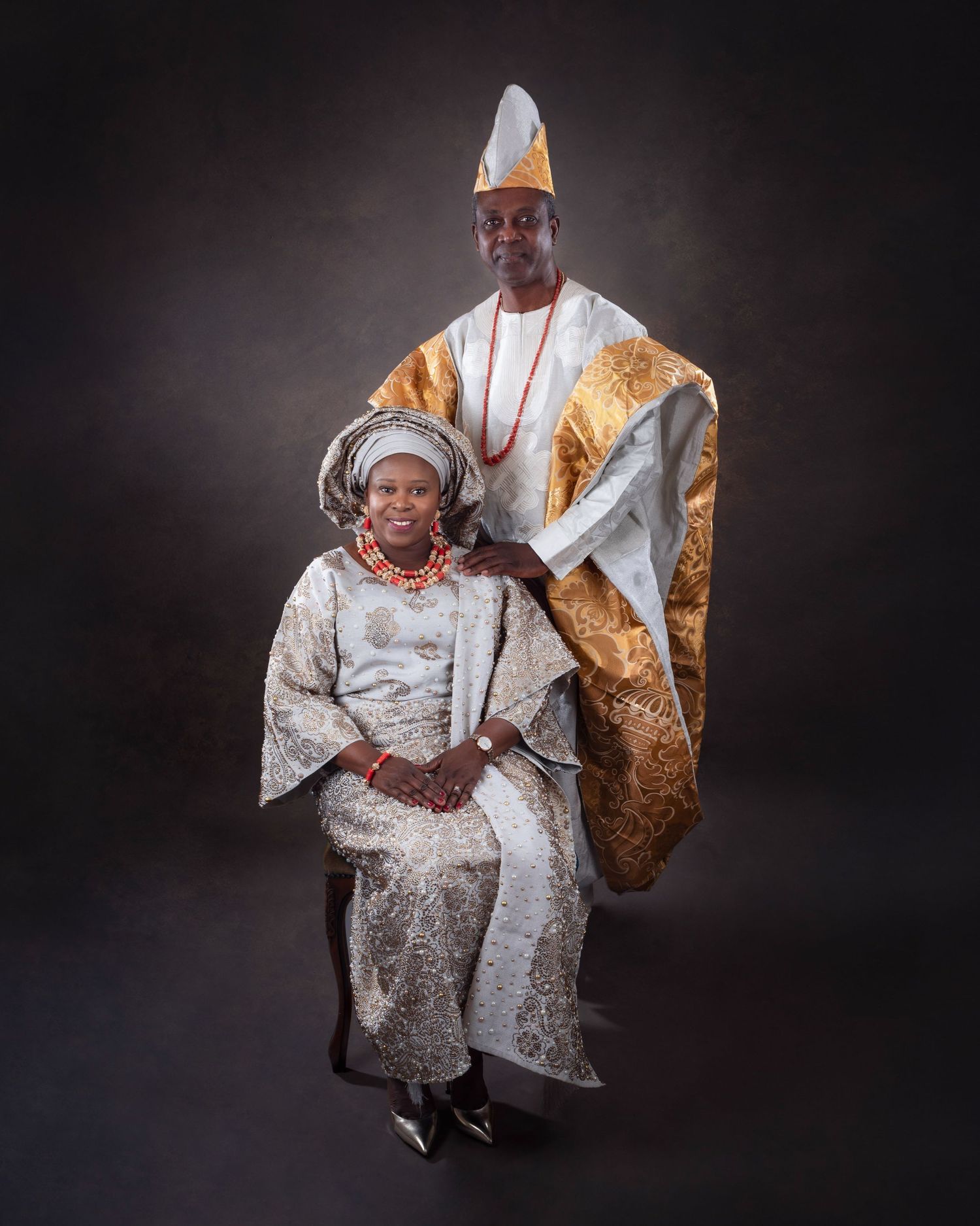 A series of studio portraits featuring traditional West African ceremonial attire with elaborate silver and gold clothing.