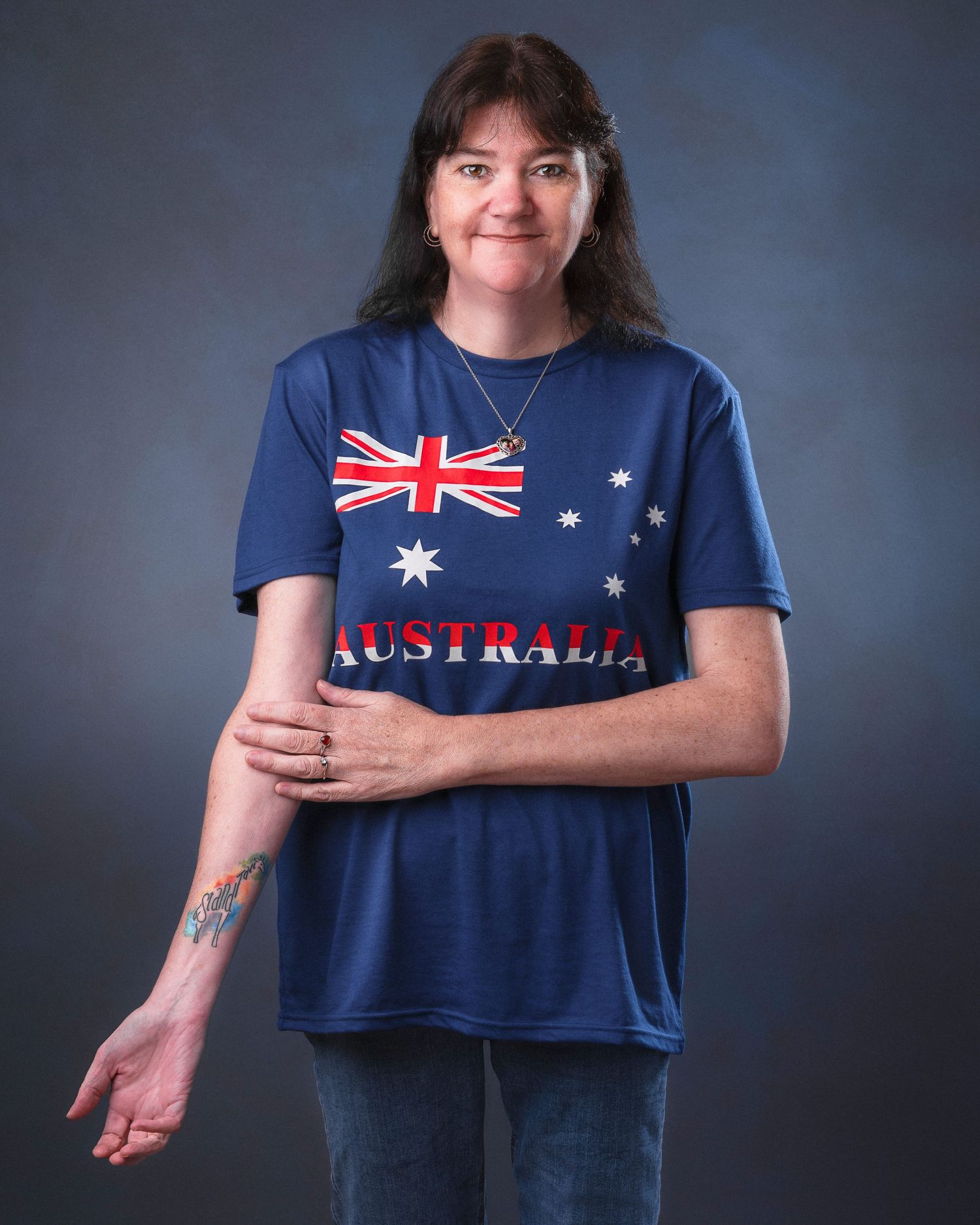 A woman wearing an Australian flag t-shirt poses against a dark background in a photo series showing different angles.