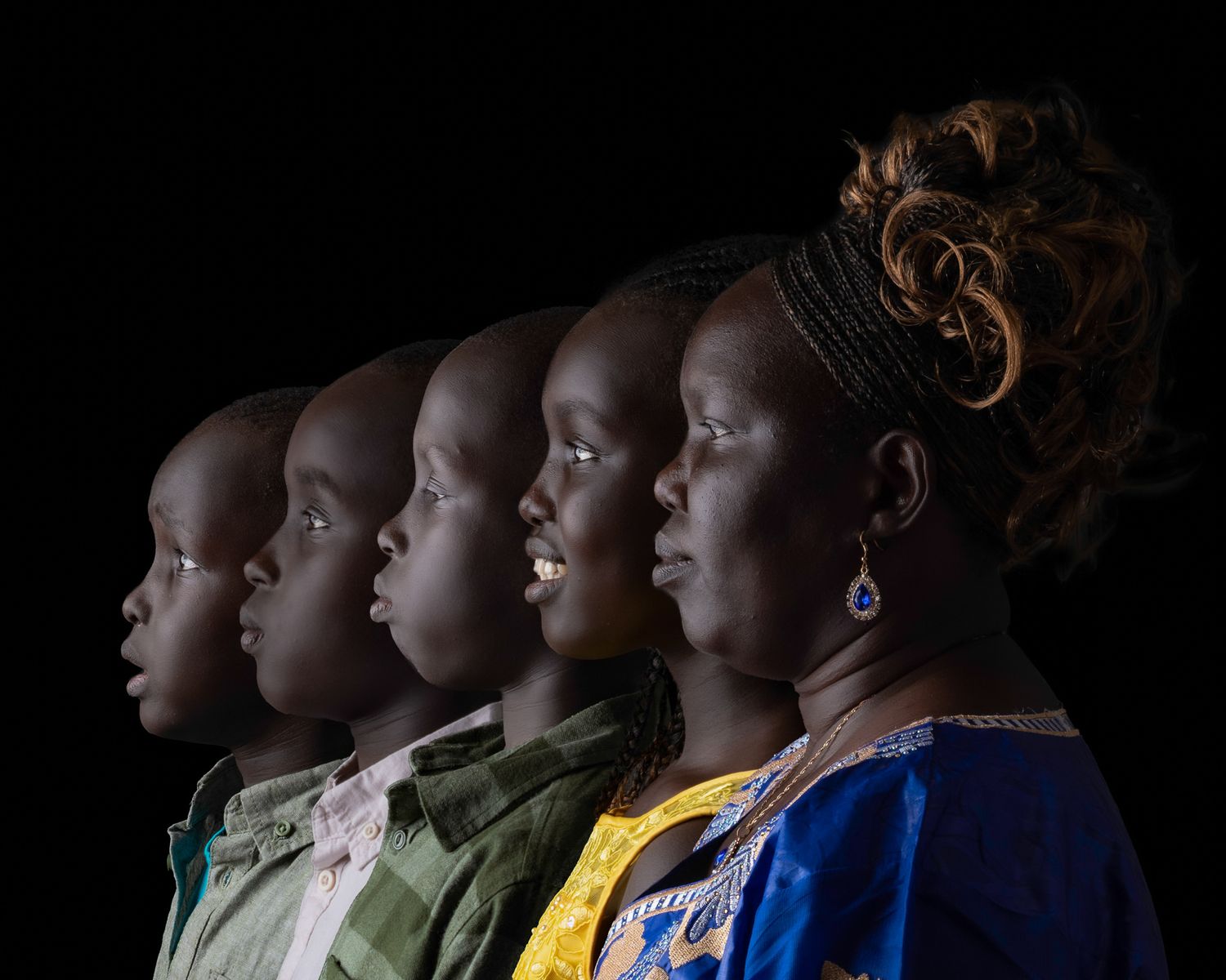 A striking profile portrait shows five people arranged in a row against a black background, wearing colorful clothing.