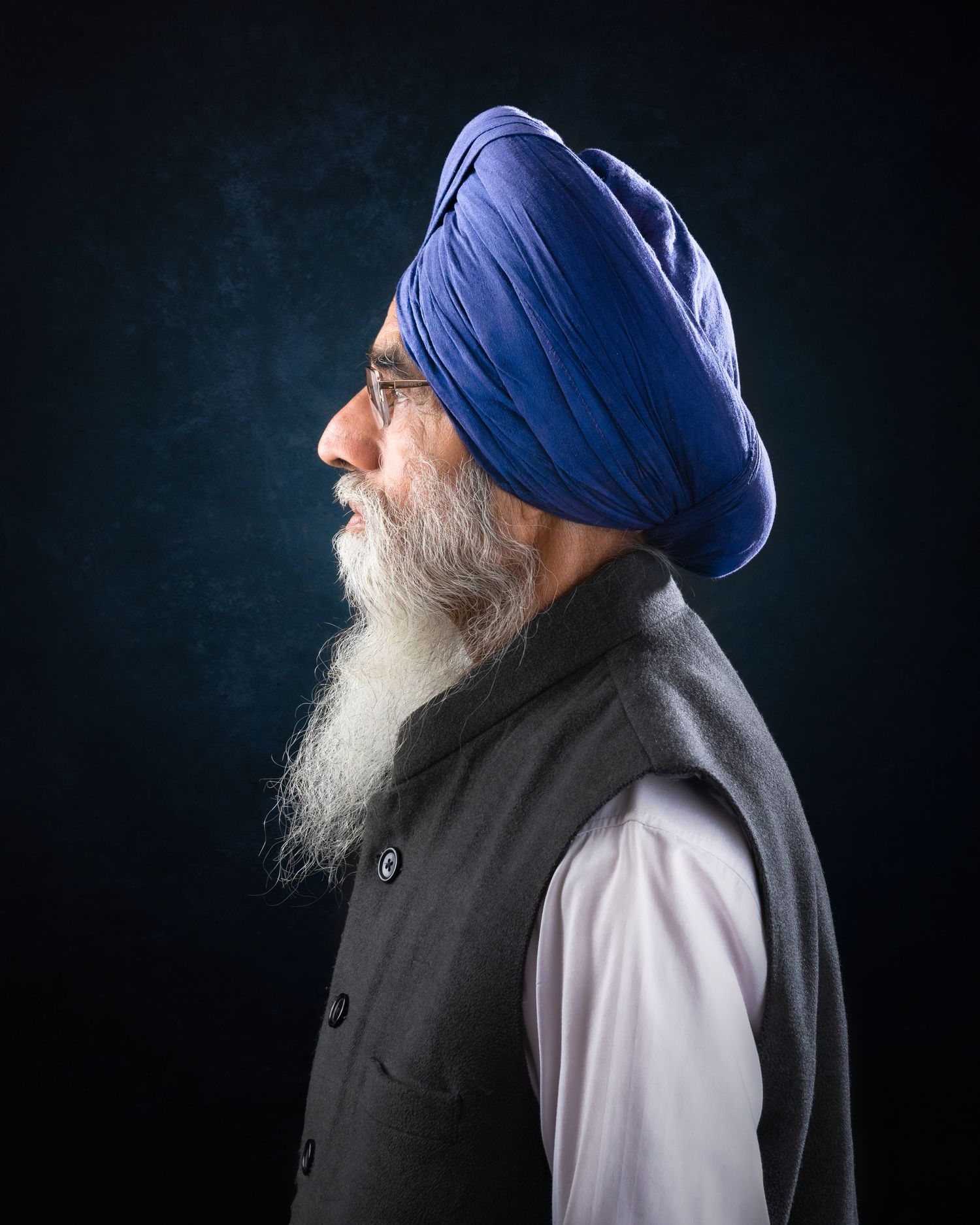 Artistic portrait series of a person in a blue turban and black vest against a dark background from different angles.