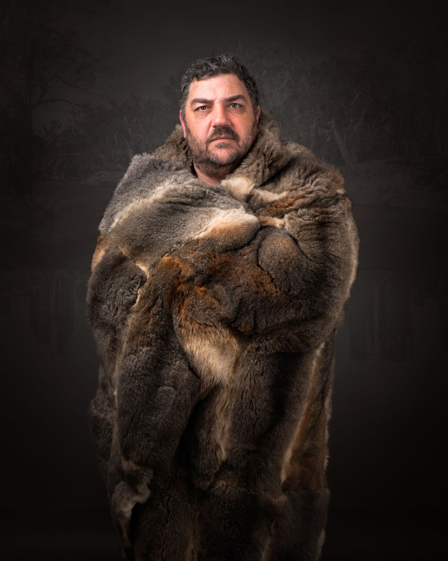 Figure draped in luxurious brown fur coat stands against dark background in dramatic portrait lighting.