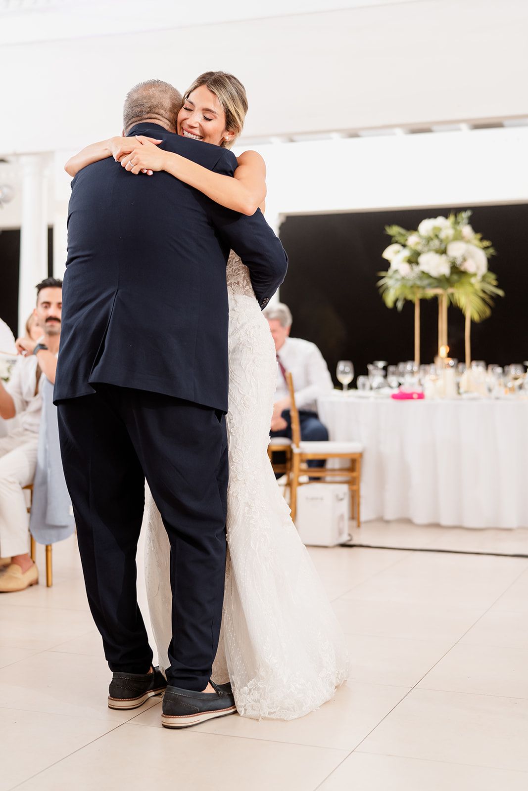 Emotional father-daughter dance moment at wedding reception.