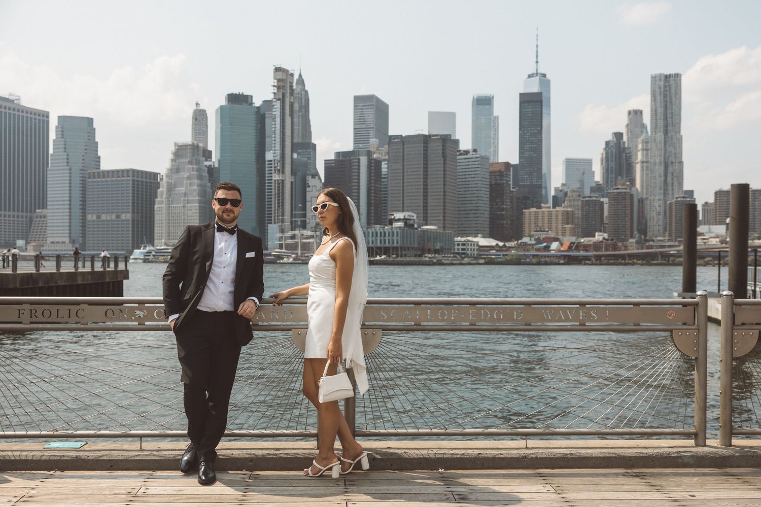 Couple posing with Manhattan skyline in the background on their NYC City Hall wedding day
