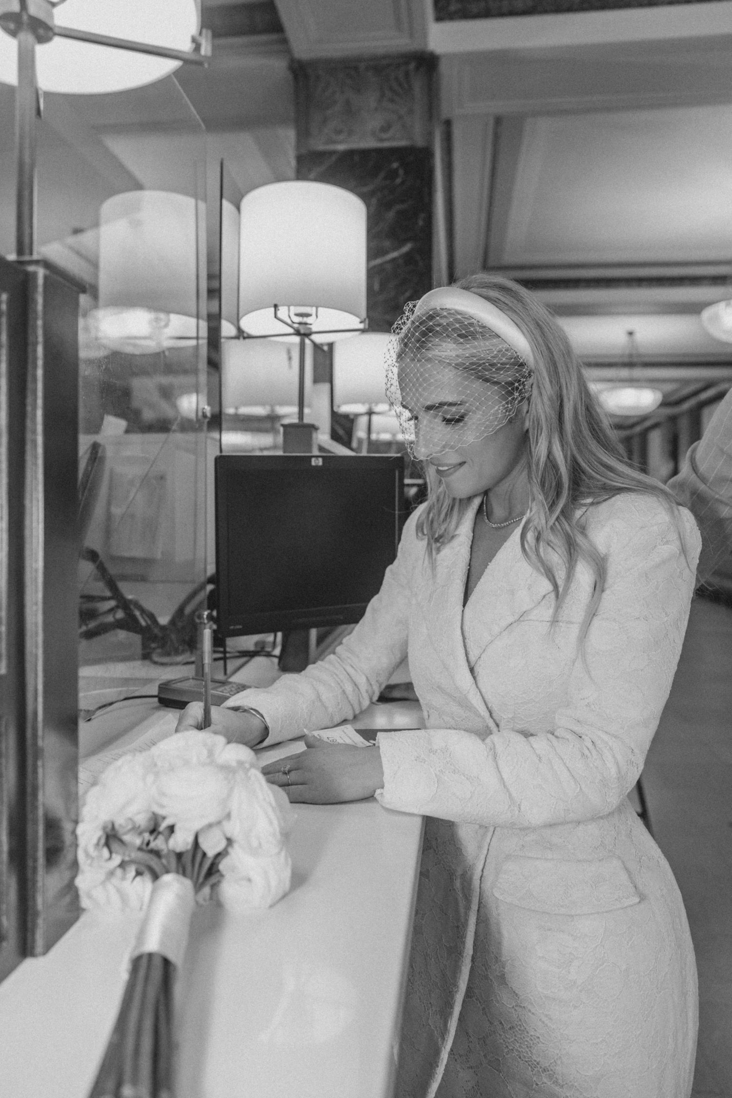 Bride signing marriage paperwork at New York City courthouse before civil ceremony
