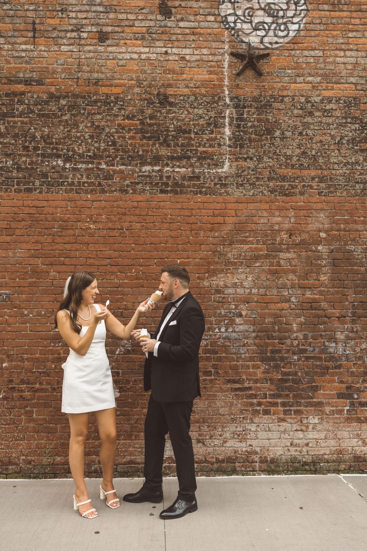 Playful elopement photo of British couple enjoying ice cream in New York City