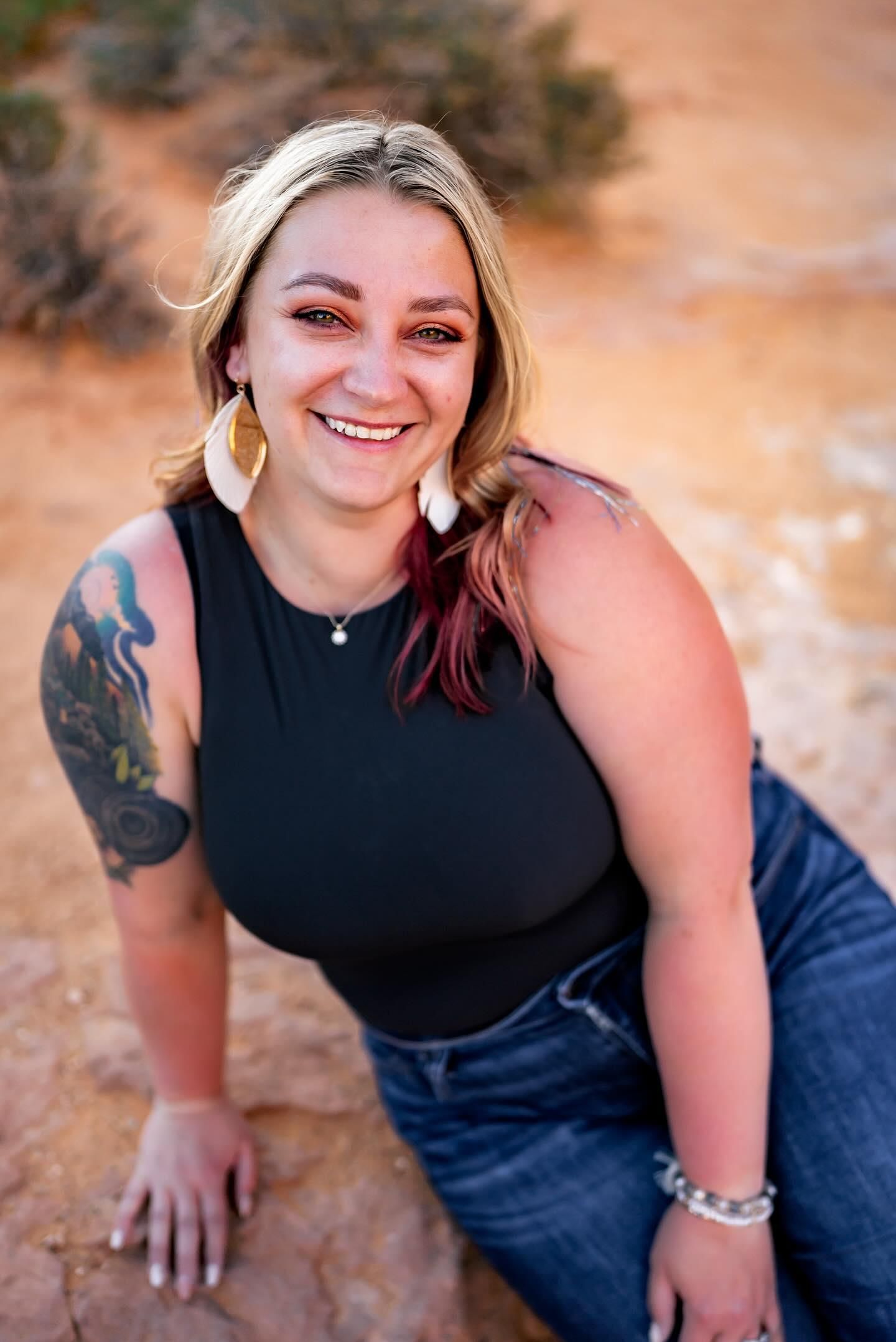 Portrait series of someone in a black sleeveless top and blue jeans sitting outdoors against a warm-toned background.