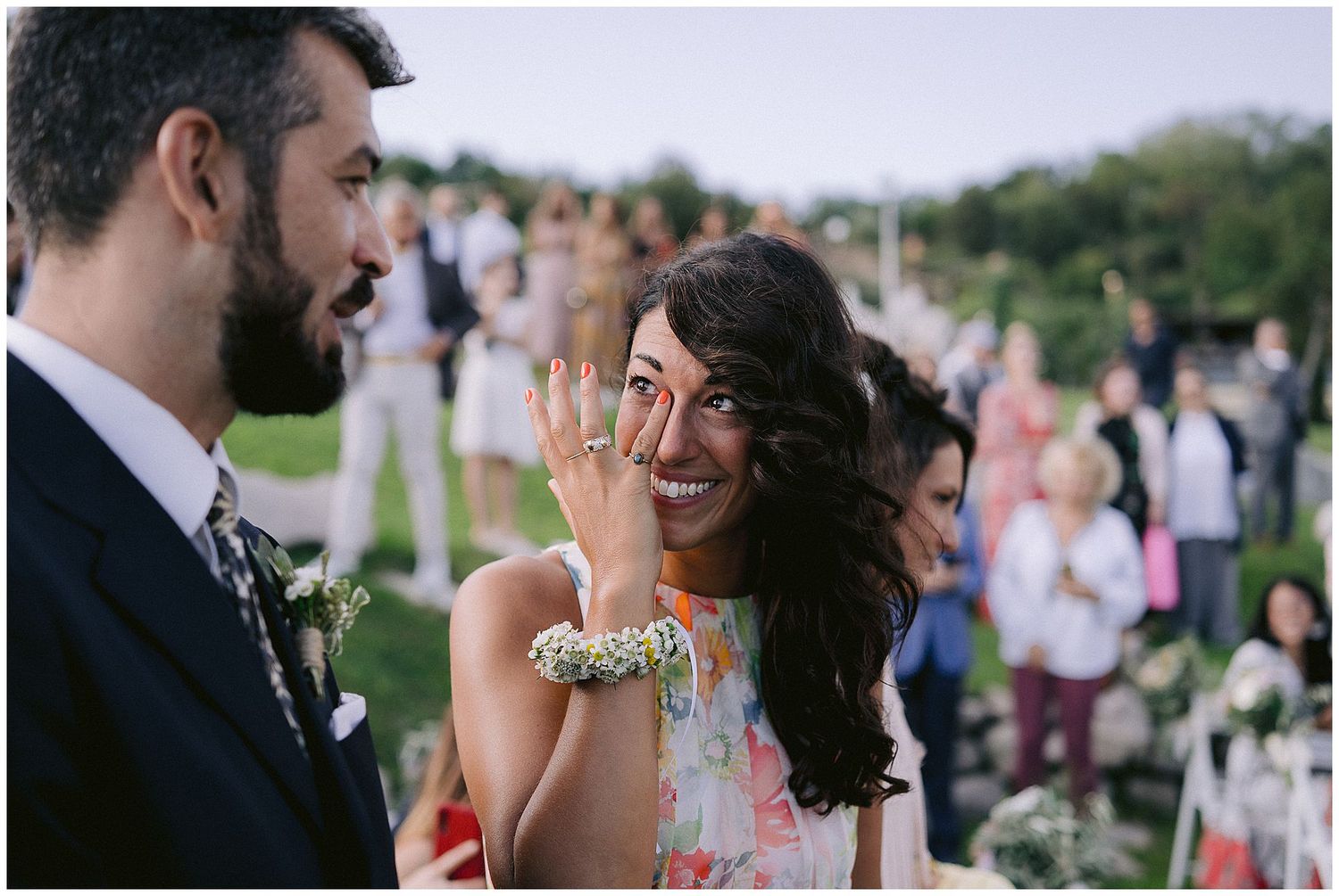An emotional moment between newlyweds during an outdoor garden reception as guests look on in the background.