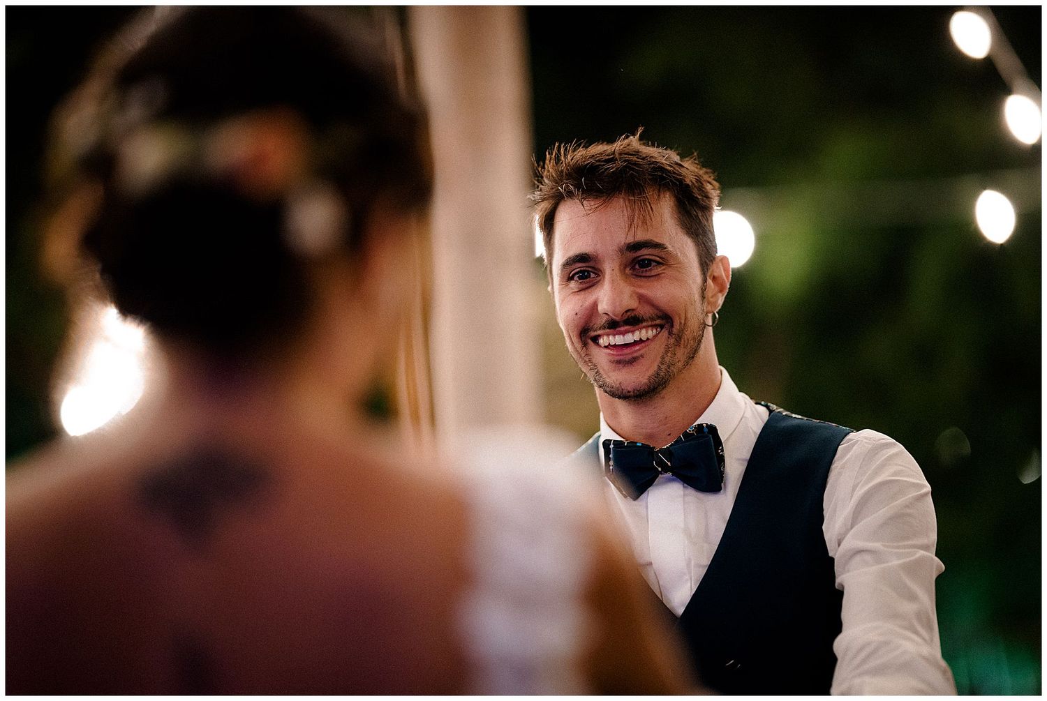 Wedding party and guests enjoying a festive celebration at an evening outdoor reception.