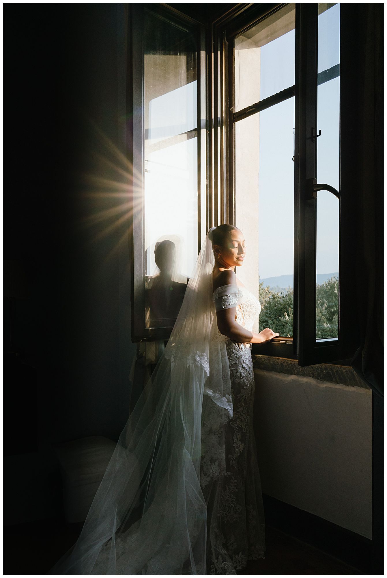 A silhouetted figure in a wedding dress stands by a window with sunlight streaming in, creating a dramatic backlit scene.