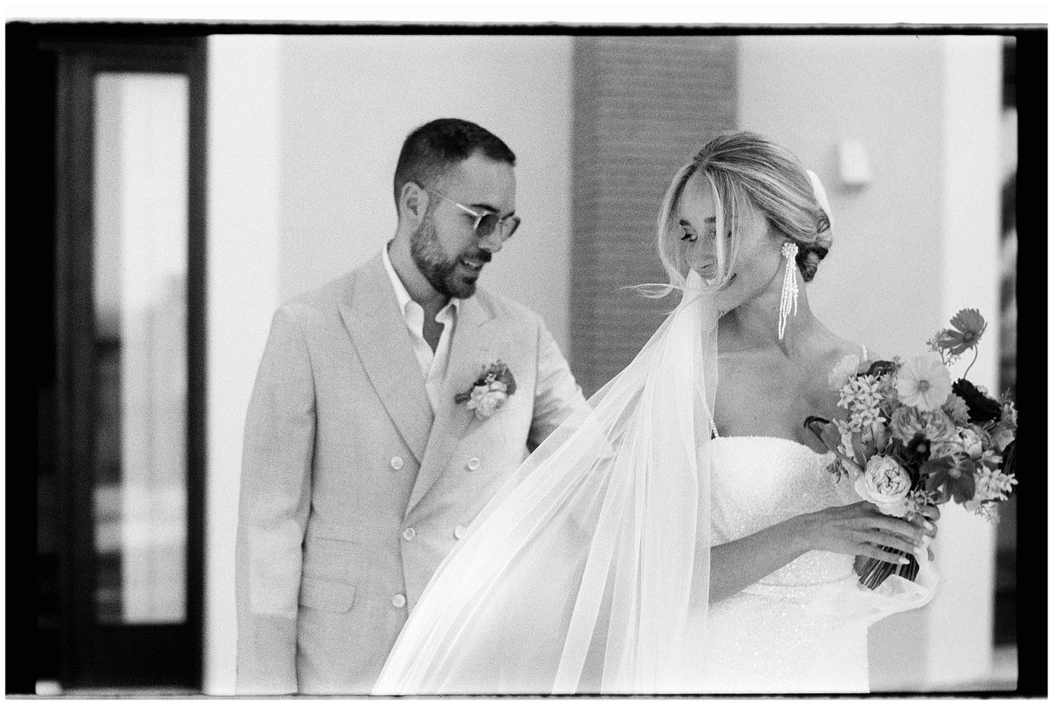 Black and white photo of a bride and groom sharing a tender first look moment during their wedding ceremony.