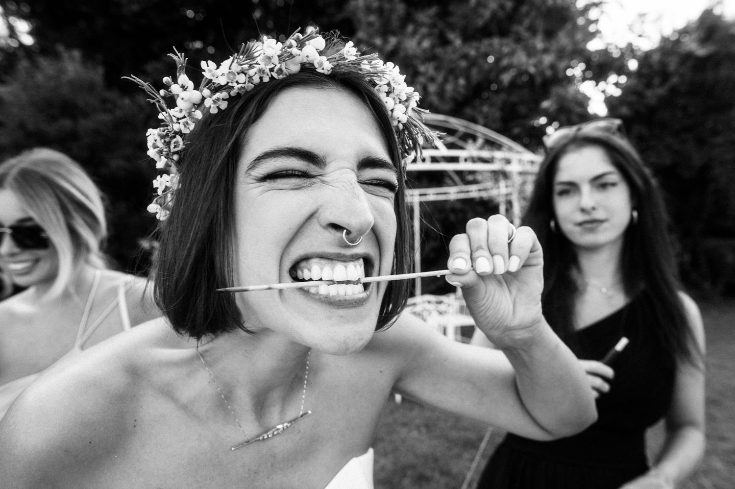 Black and white photo showing someone wearing a flower crown and making an energetic expression.