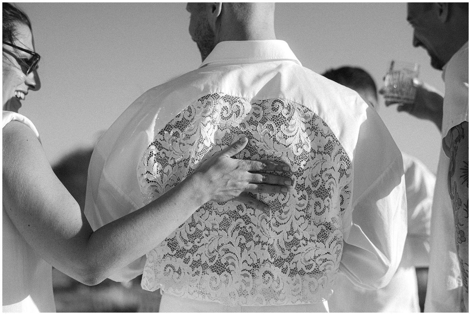 Black and white photo showing ornate tattoo artwork covering someone's back in an intricate swirling pattern.