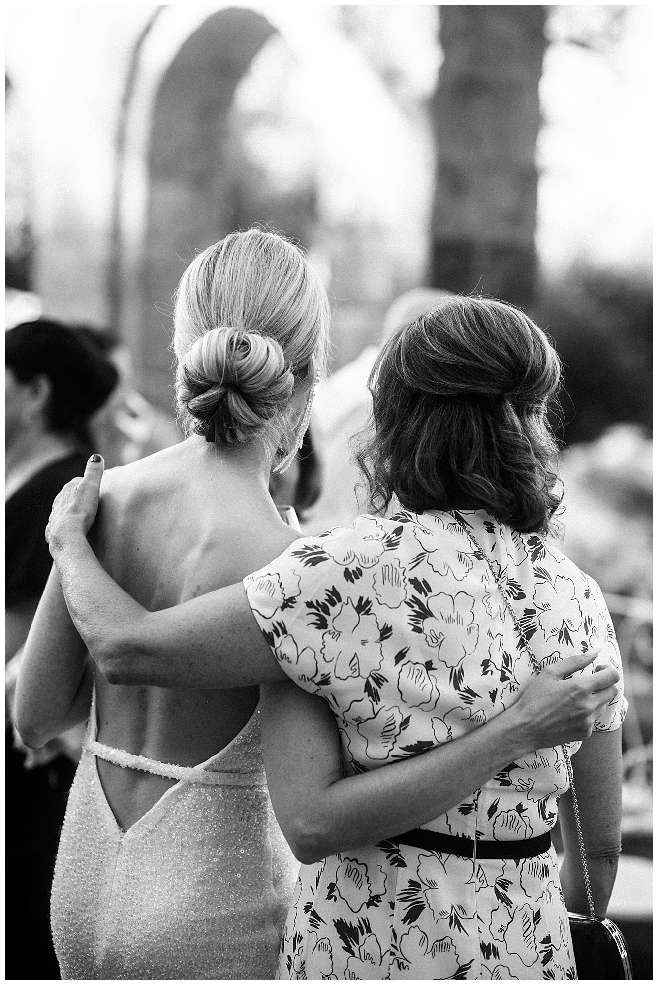 A black and white image sequence showing two friends embracing and walking together in floral and casual clothing.