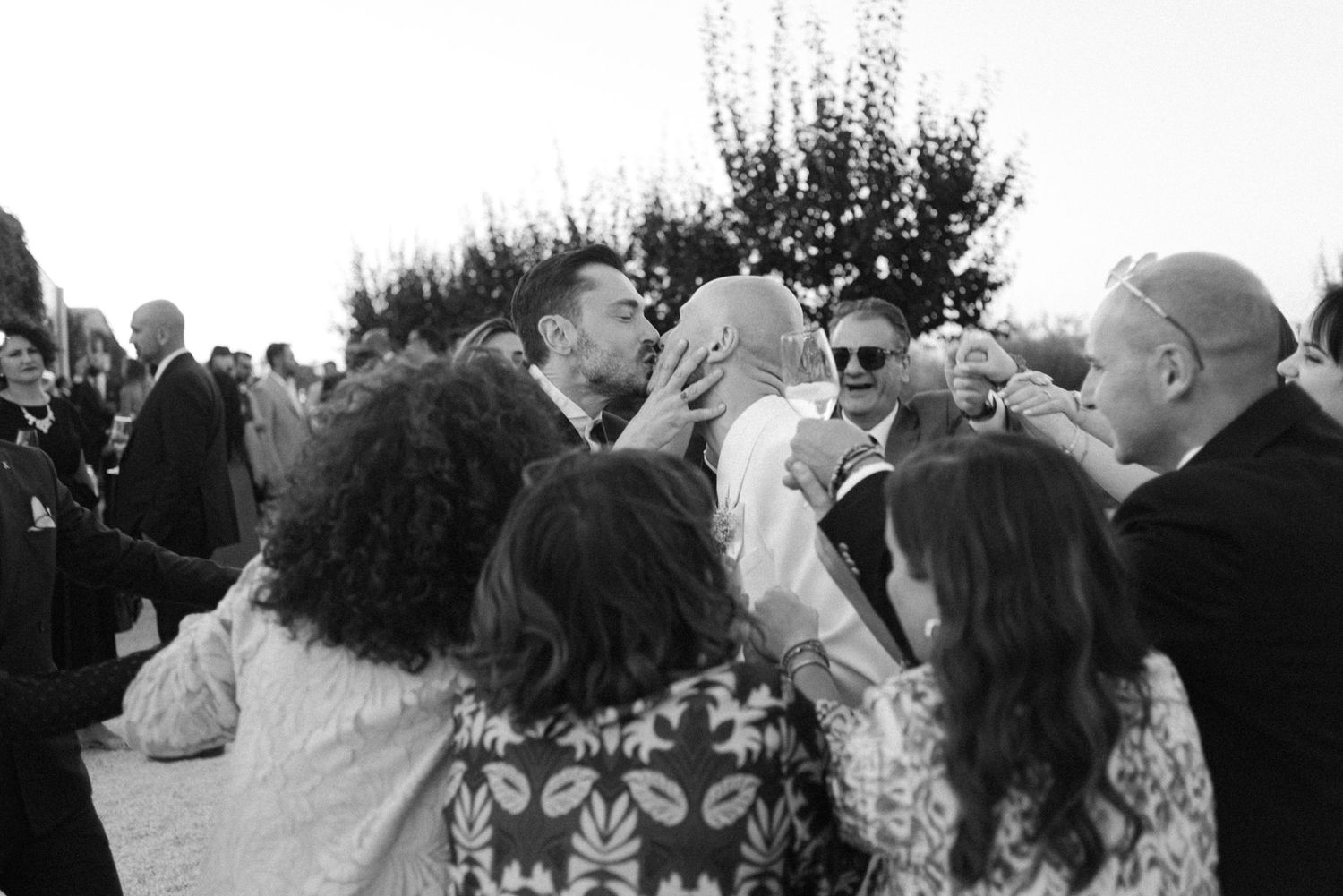 Black and white candid of wedding guests celebrating during reception.