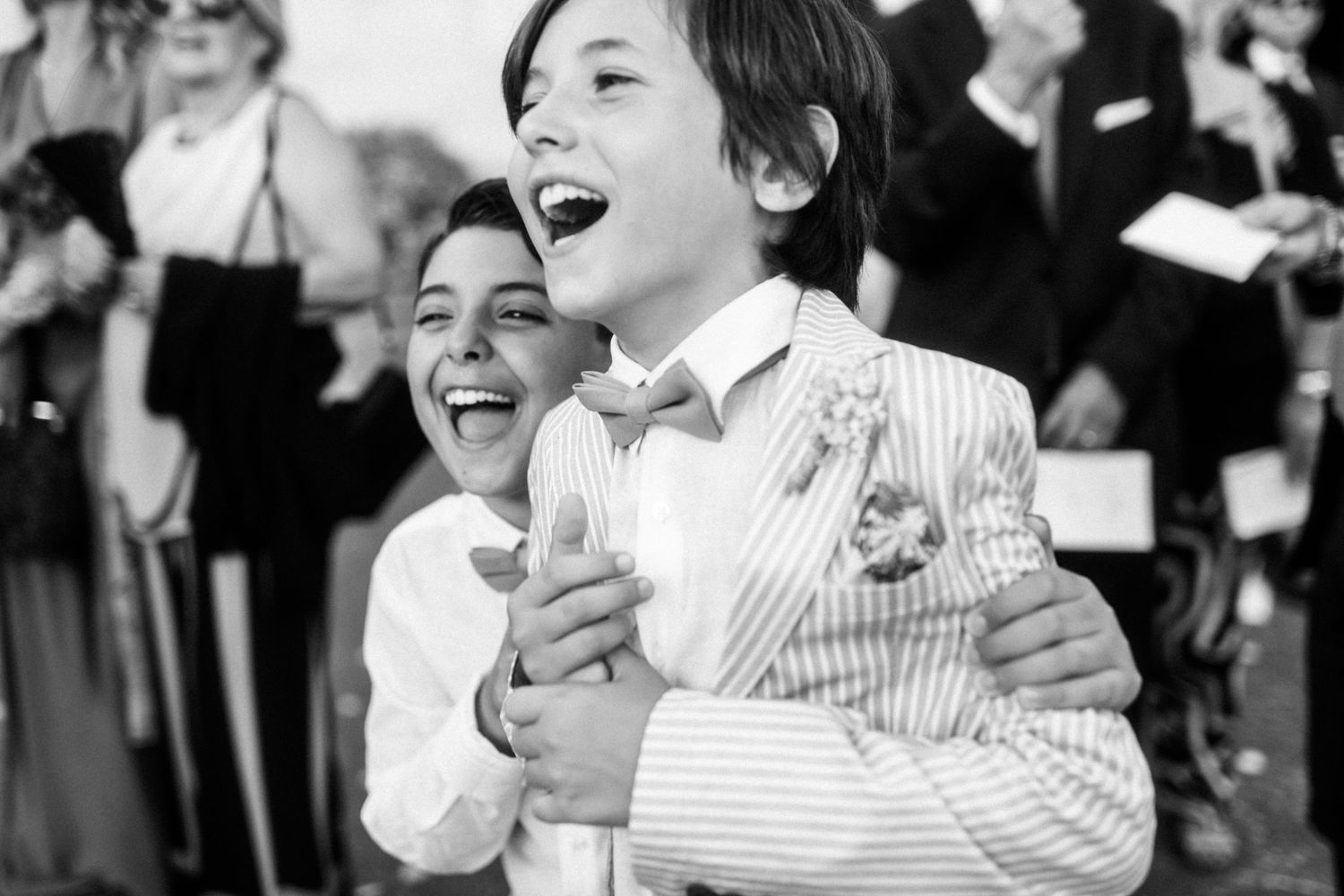 A joyful black and white photo capturing two people laughing together at a formal event.