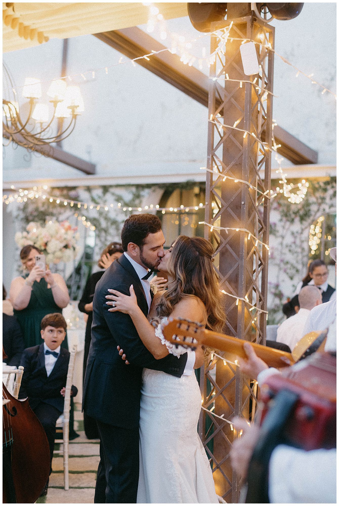 A romantic first dance at a wedding reception decorated with twinkling lights and an ornate gold column.