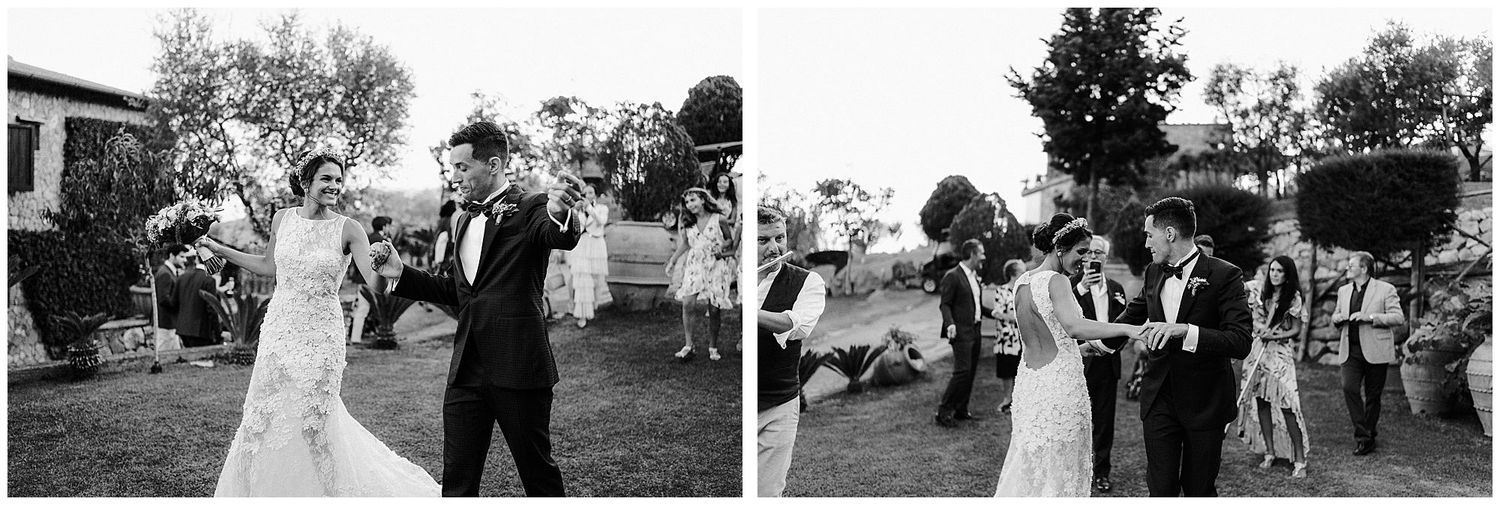 Wedding couple dance together outdoors as guests celebrate and dance behind them during an outdoor reception.