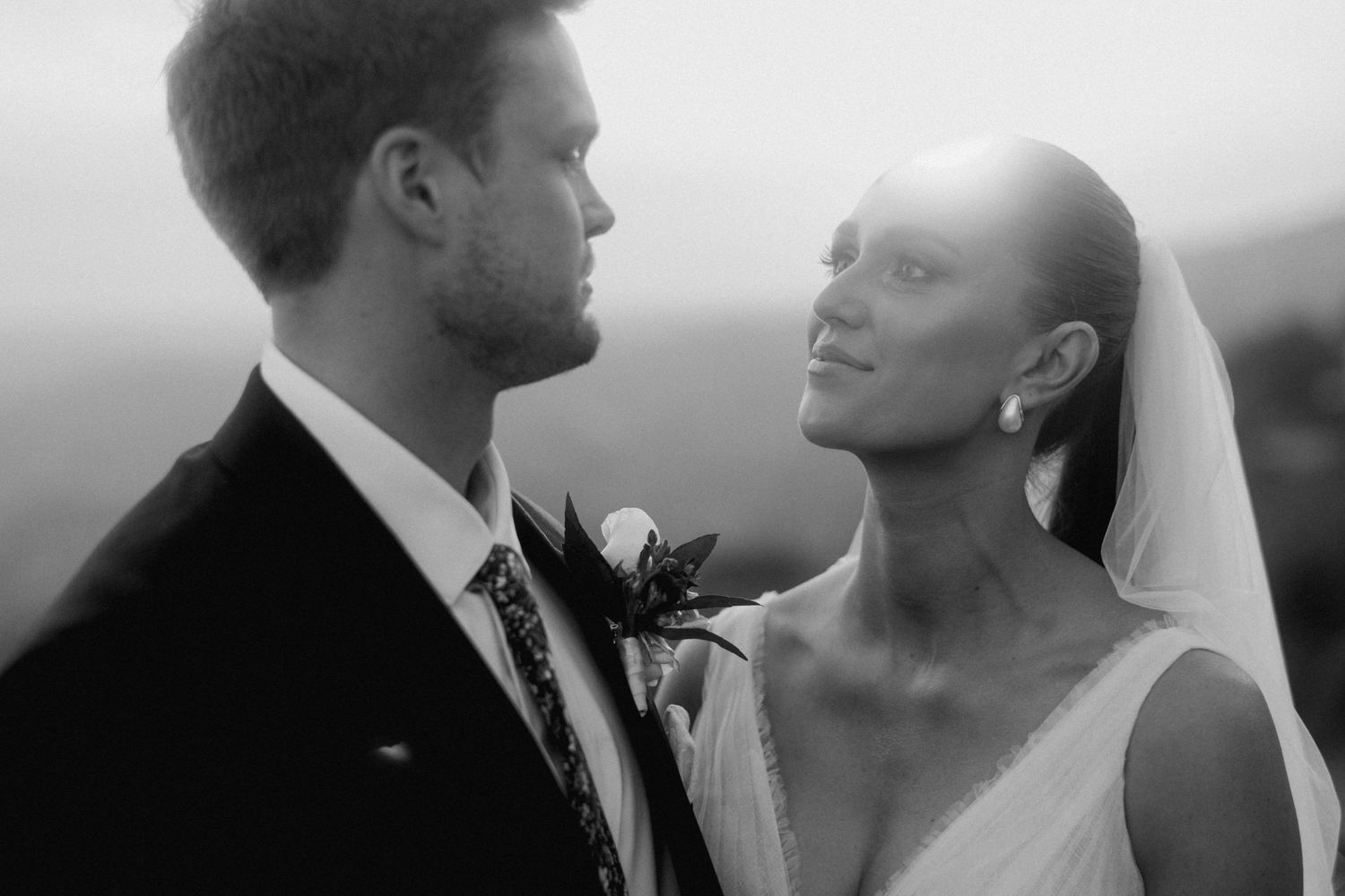 Intimate black and white portrait of newlyweds sharing romantic moment.