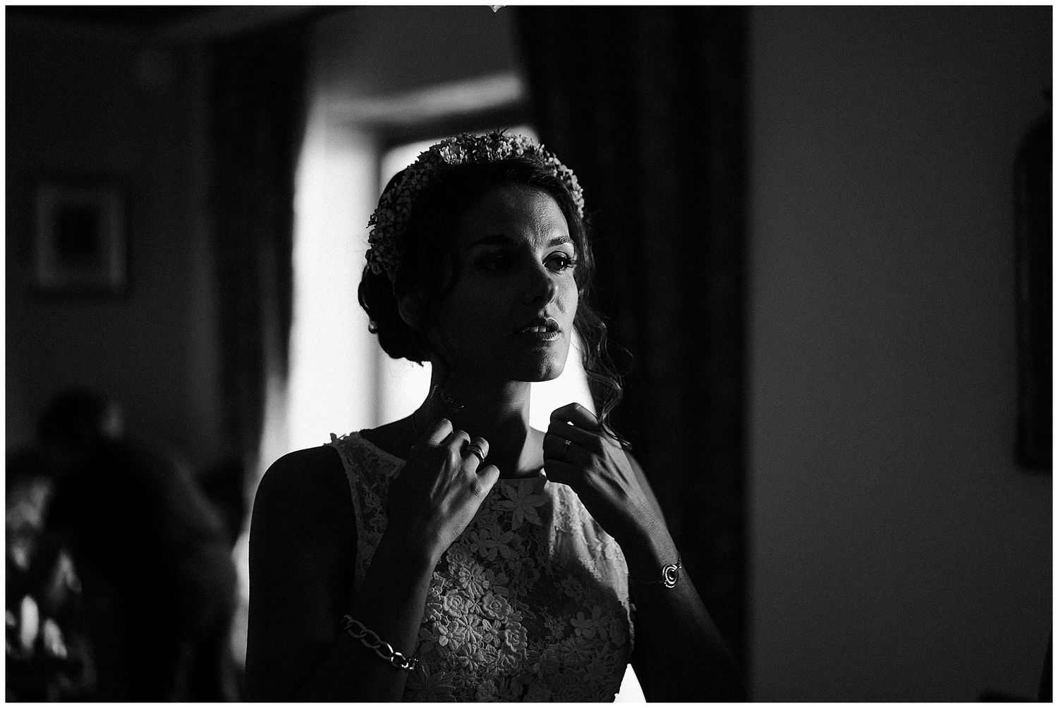 Black and white photograph shows a solo performer illuminated by dramatic lighting as they sing into a microphone.