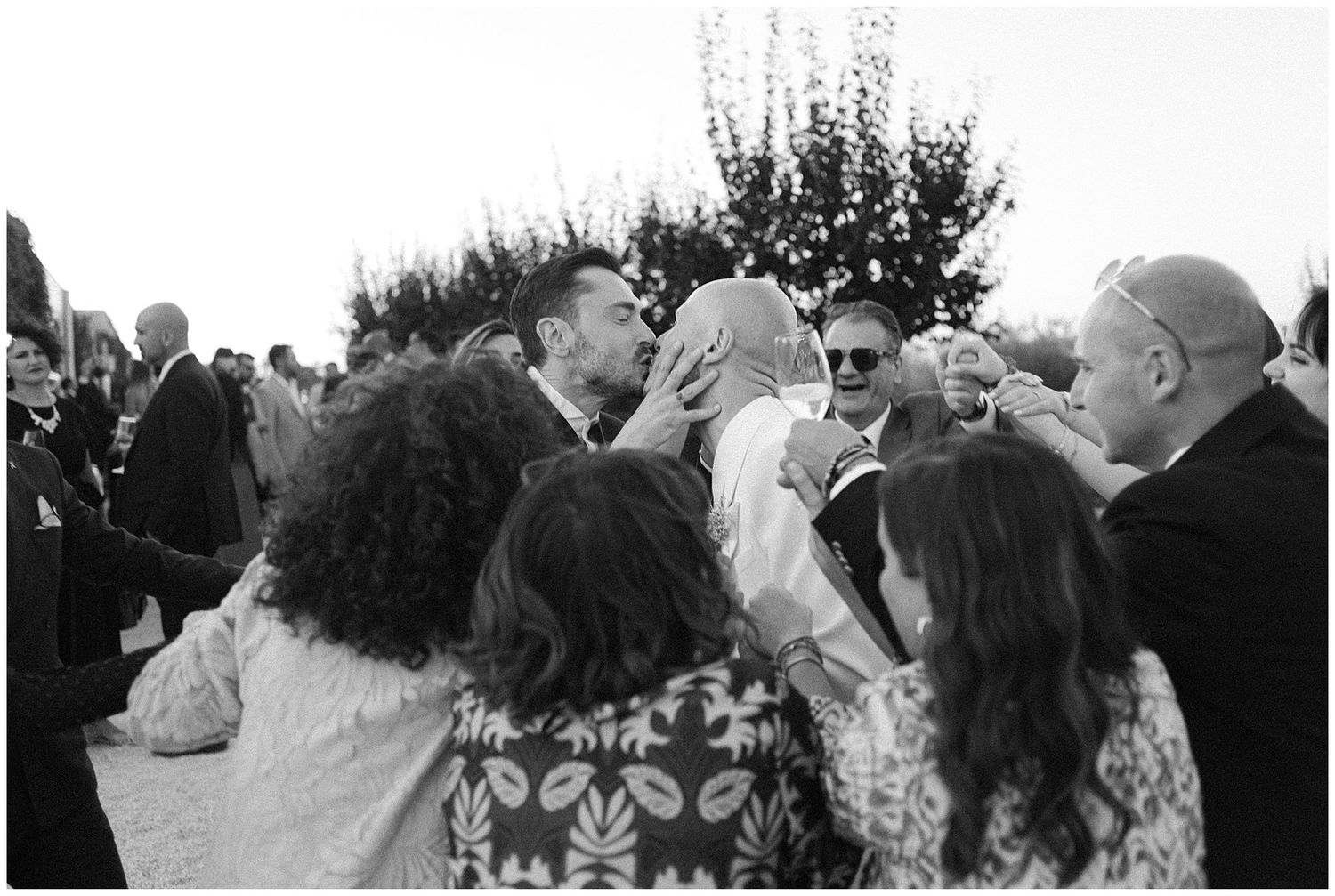 Vintage black and white photograph showing a crowd of people gathered outdoors at a social event.