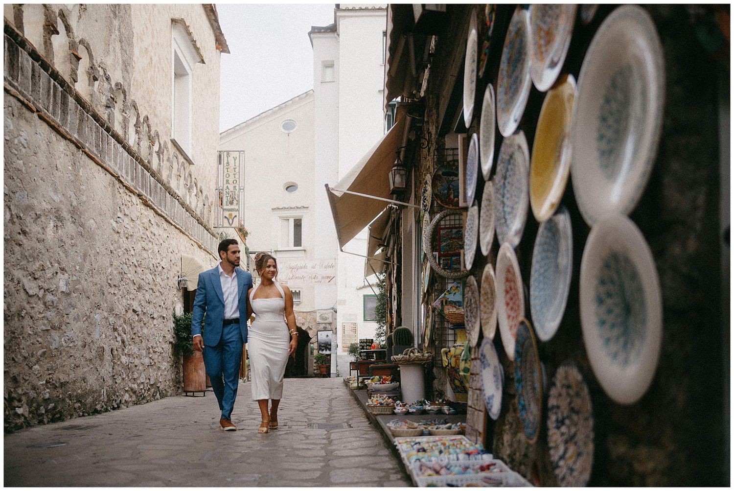 A series of black and white photos showing couples walking together along a stone-walled urban street.