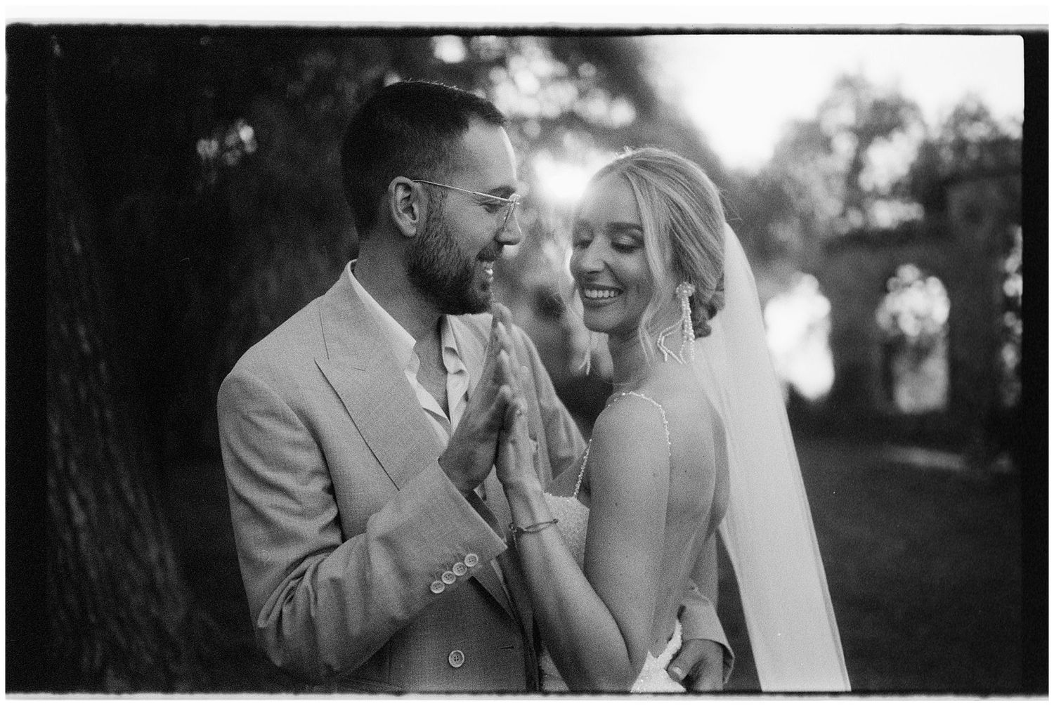 A joyful couple shares an intimate moment together outdoors in black and white on their wedding day.
