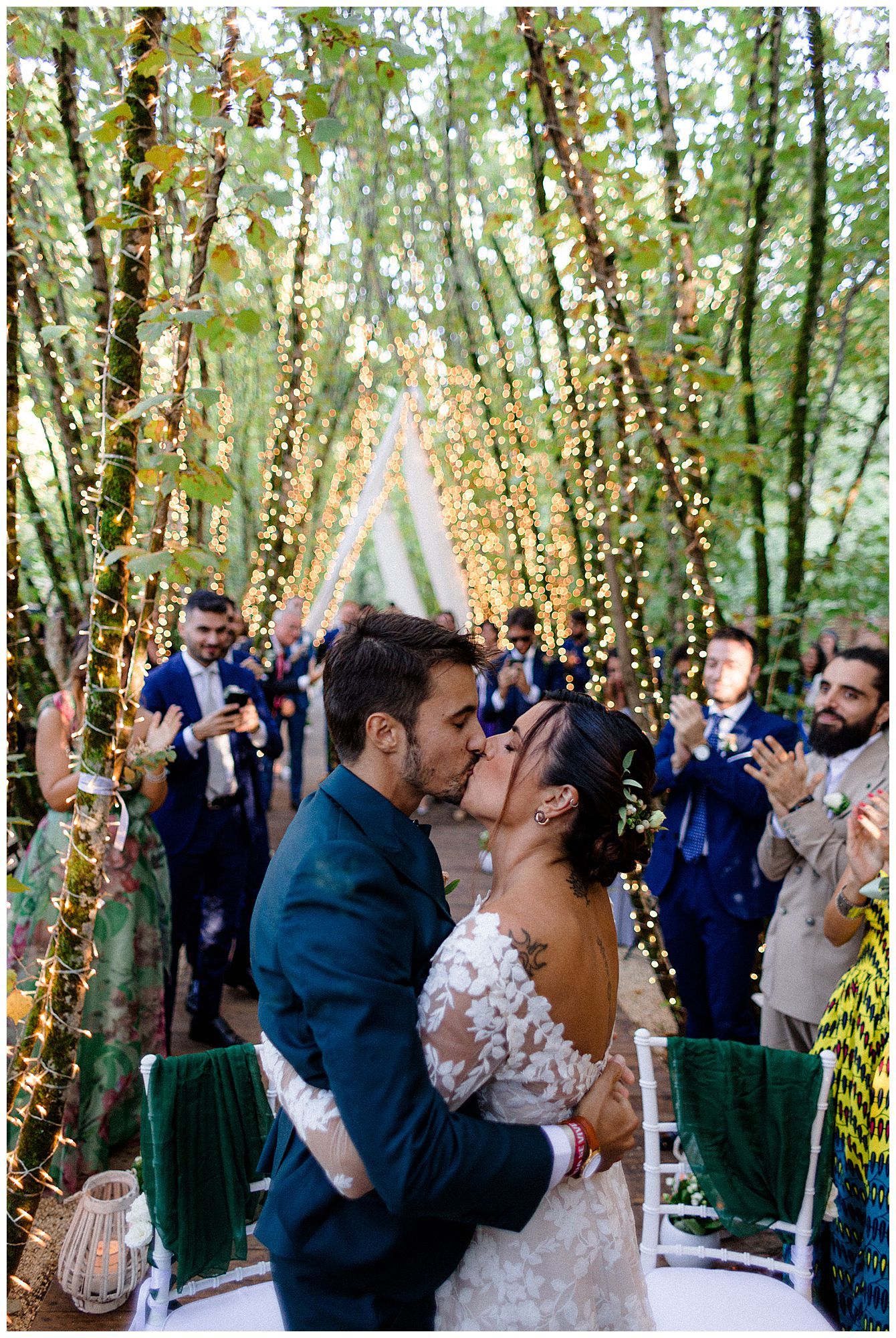 Wedding couple shares first dance under magical twinkle light canopy in forest setting.