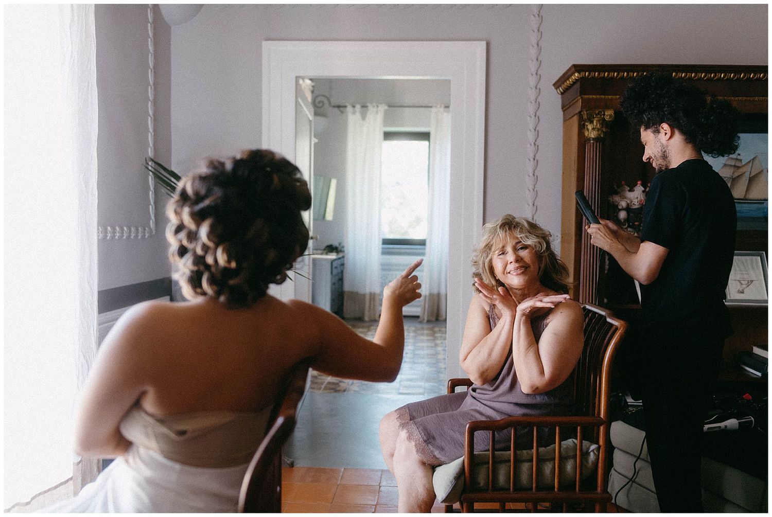 Behind-the-scenes photography session showing a photo shoot setup in a sunlit interior room with professional equipment.