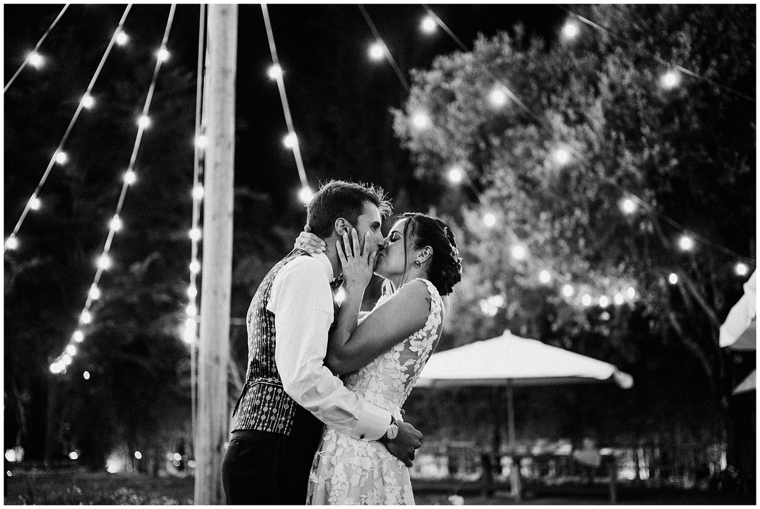 Romantic nighttime dance between newlyweds under twinkling string lights.