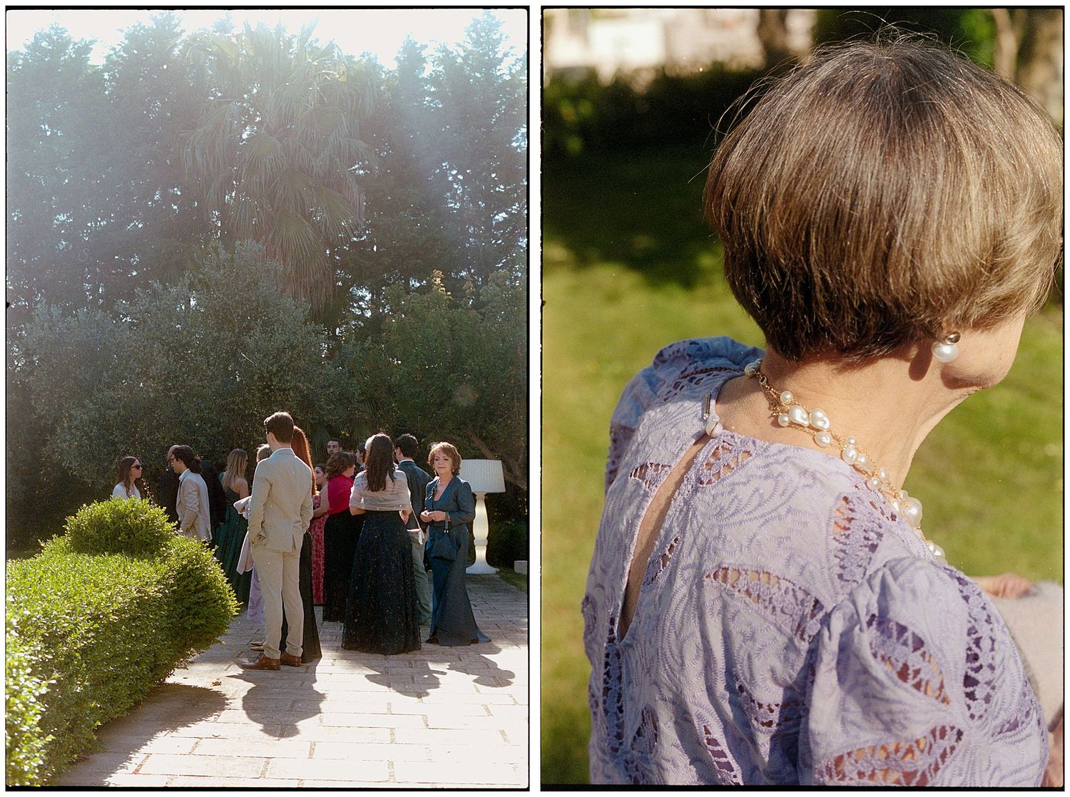 Group of wedding guests gathered outdoors in sunlit garden setting with elegant lace-detailed outfit in foreground.