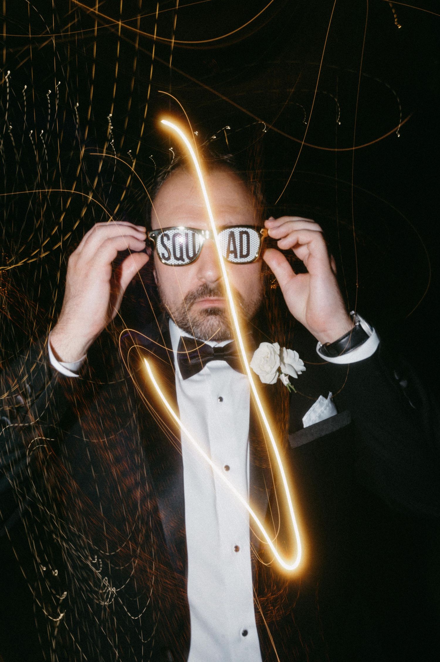 Creative nighttime portrait with light streaks and person in tuxedo with bowtie.