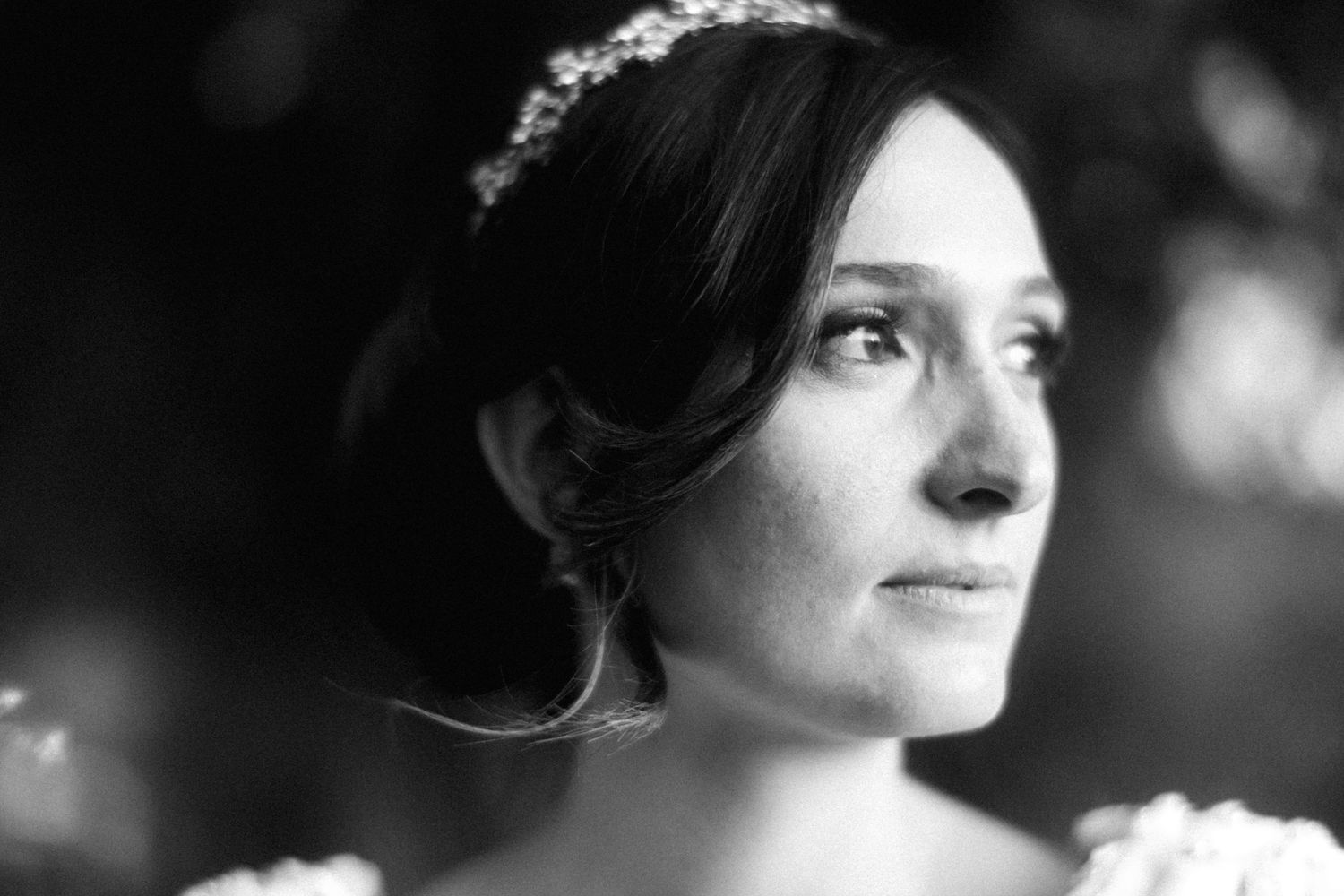 Black and white profile portrait of a bride wearing a tiara and looking contemplative.