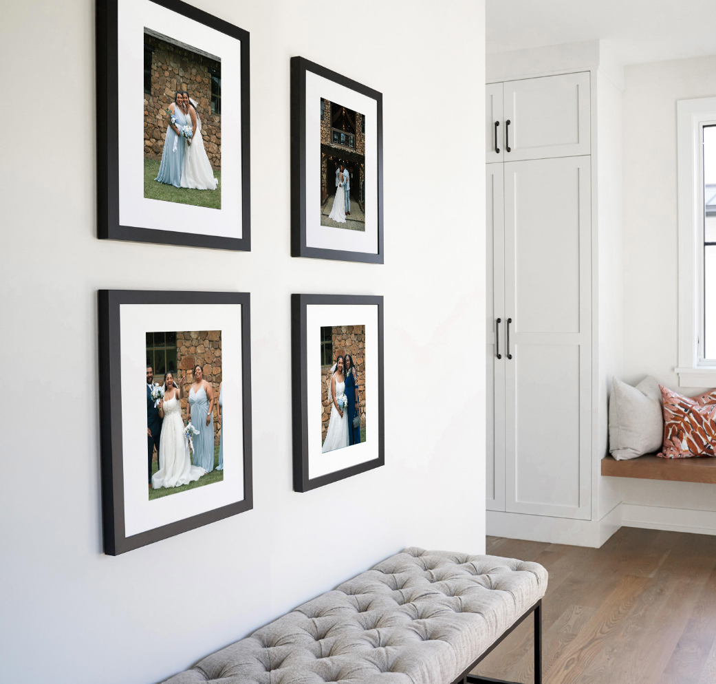 Gallery wall displaying four framed wedding photographs above grey bench.