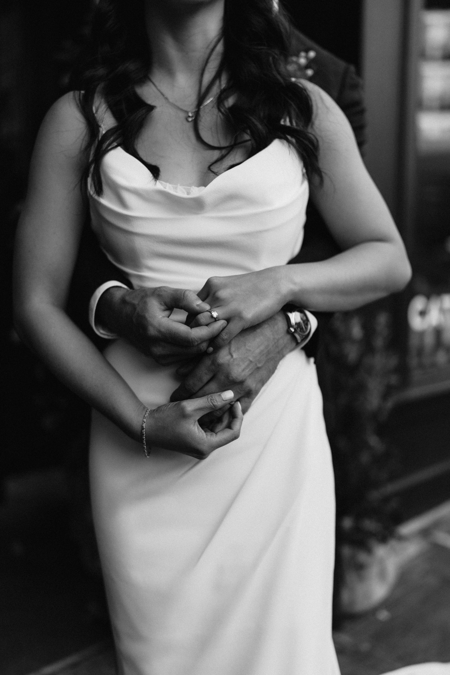 Close up of elegant white wedding dress with draped neckline detail in black and white.