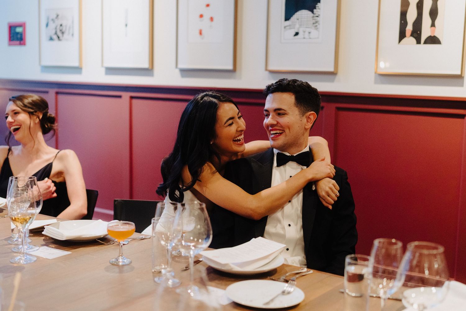 Wedding guests dining at elegant tables in contemporary art gallery space.