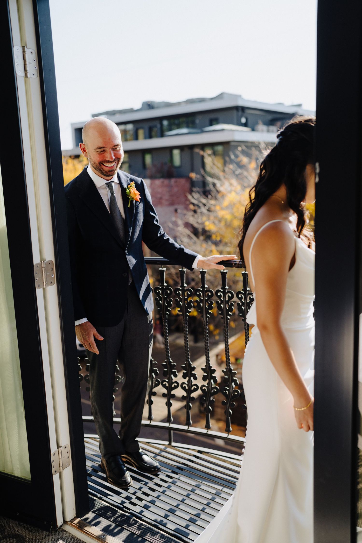 Couple shares their first look moment on a balcony during their wedding day celebration.