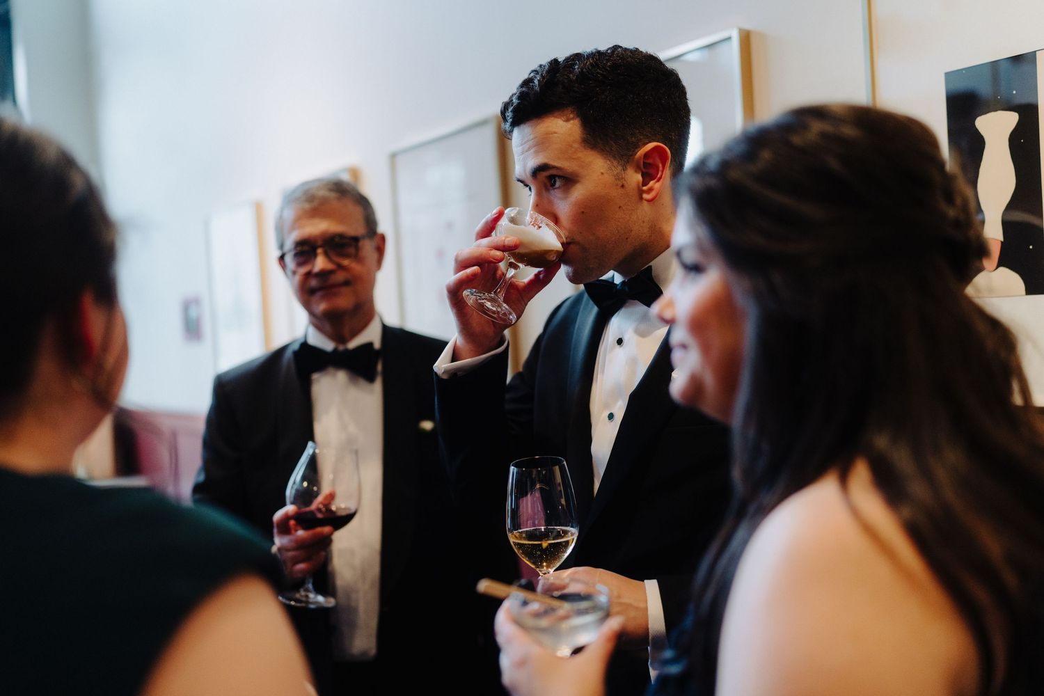 Wedding guests enjoying wine and conversation during an indoor reception.