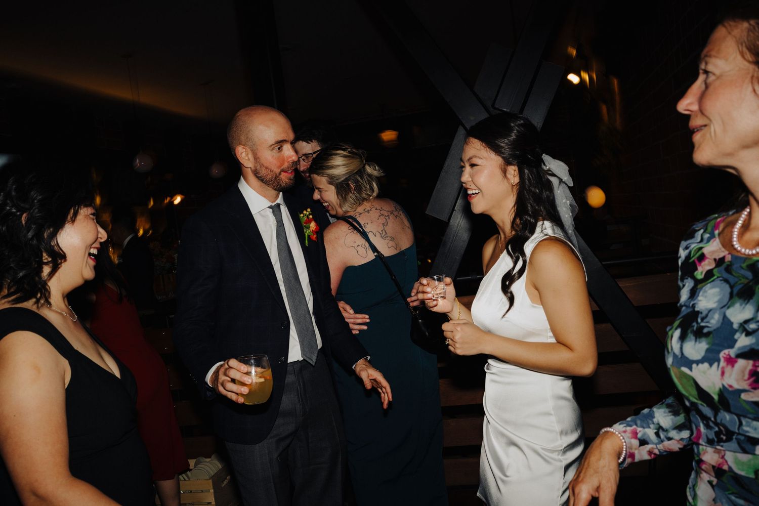 Reception guests enjoying conversation and drinks at an evening wedding celebration.