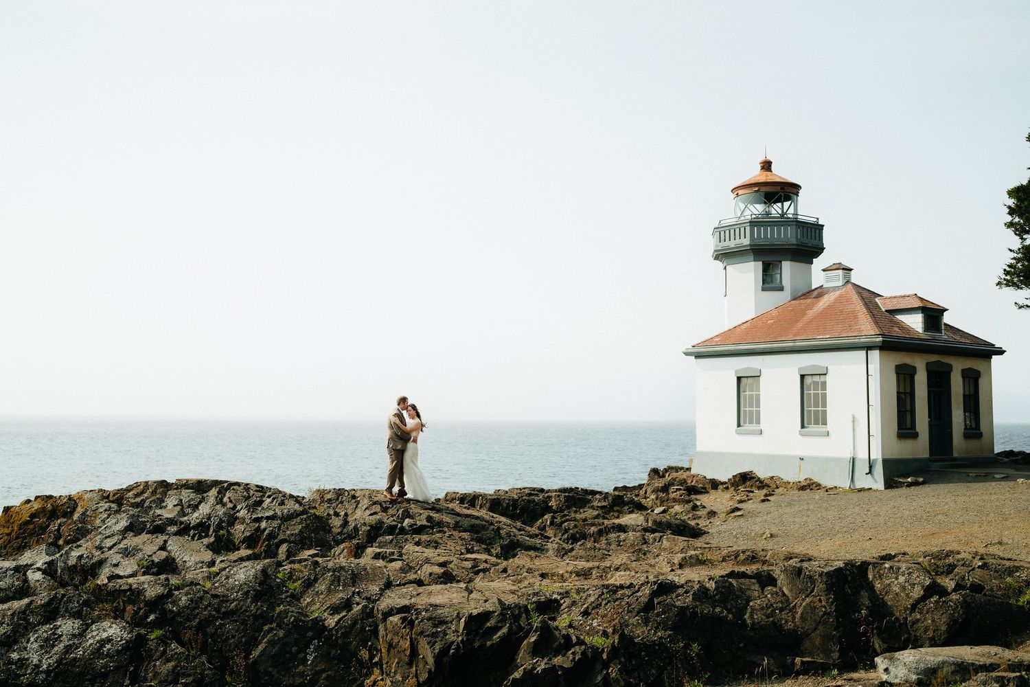A scenic lighthouse stands on rocky coastal cliffs overlooking the ocean.
