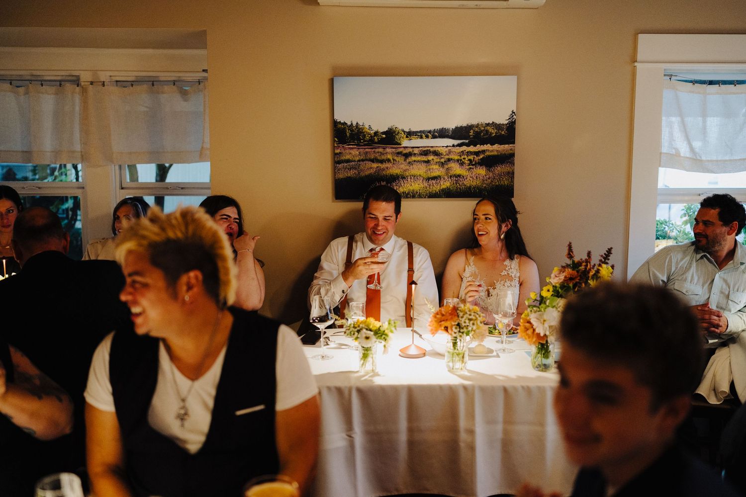 Guests enjoying a wedding reception with candlelight and table settings in a warm-lit restaurant setting.