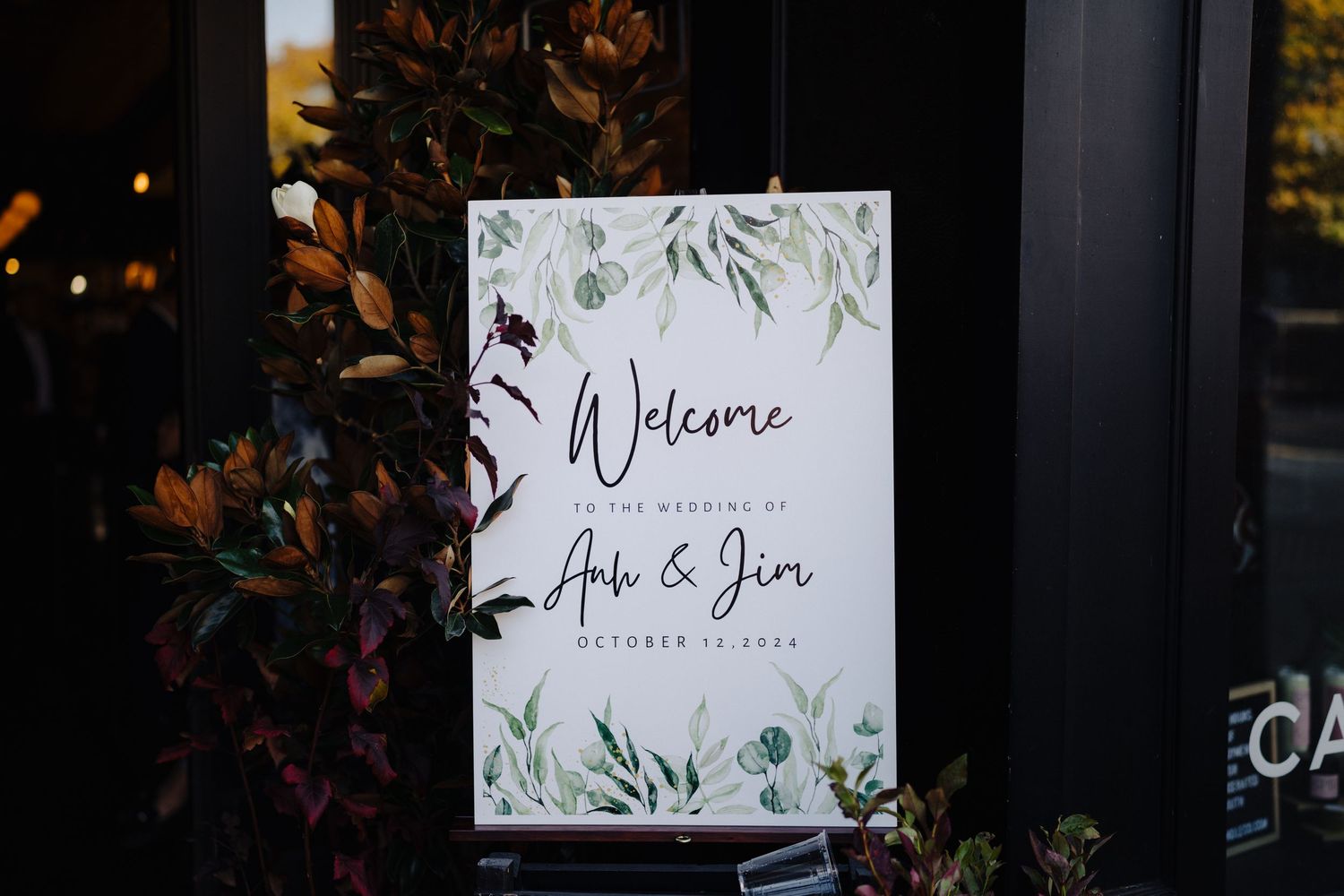 Elegant wedding welcome sign with floral design and couple's names.