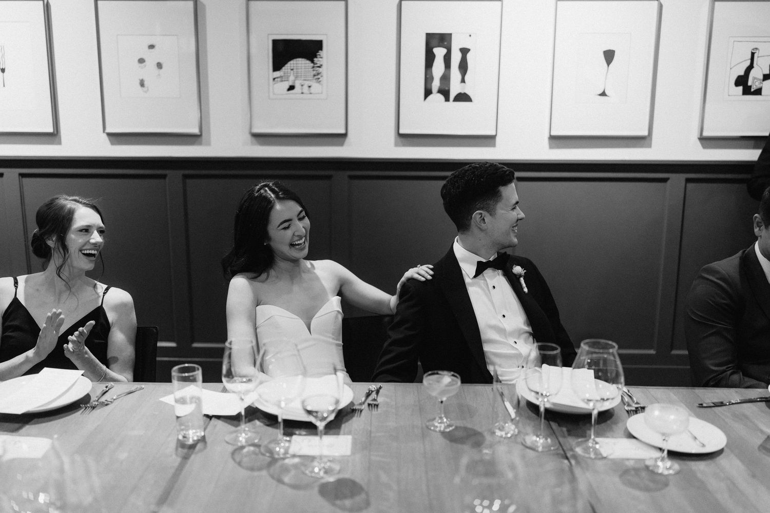 Wedding party enjoying dinner and conversation at an elegant reception.