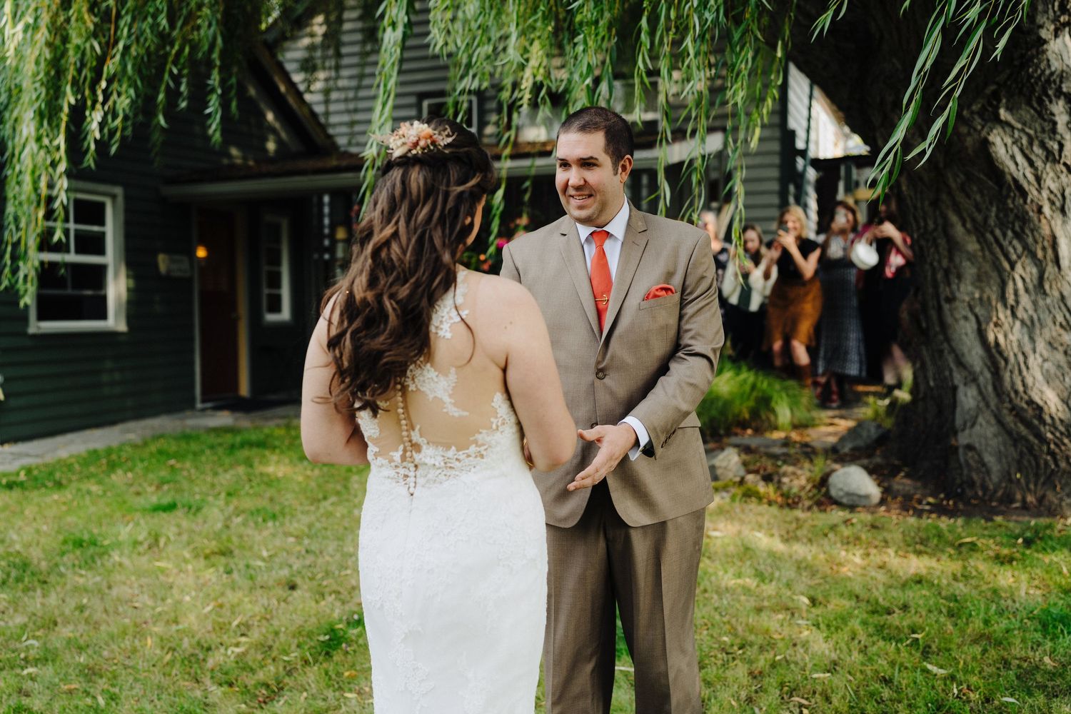 A couple shares an intimate outdoor first look moment during their backyard garden wedding ceremony.