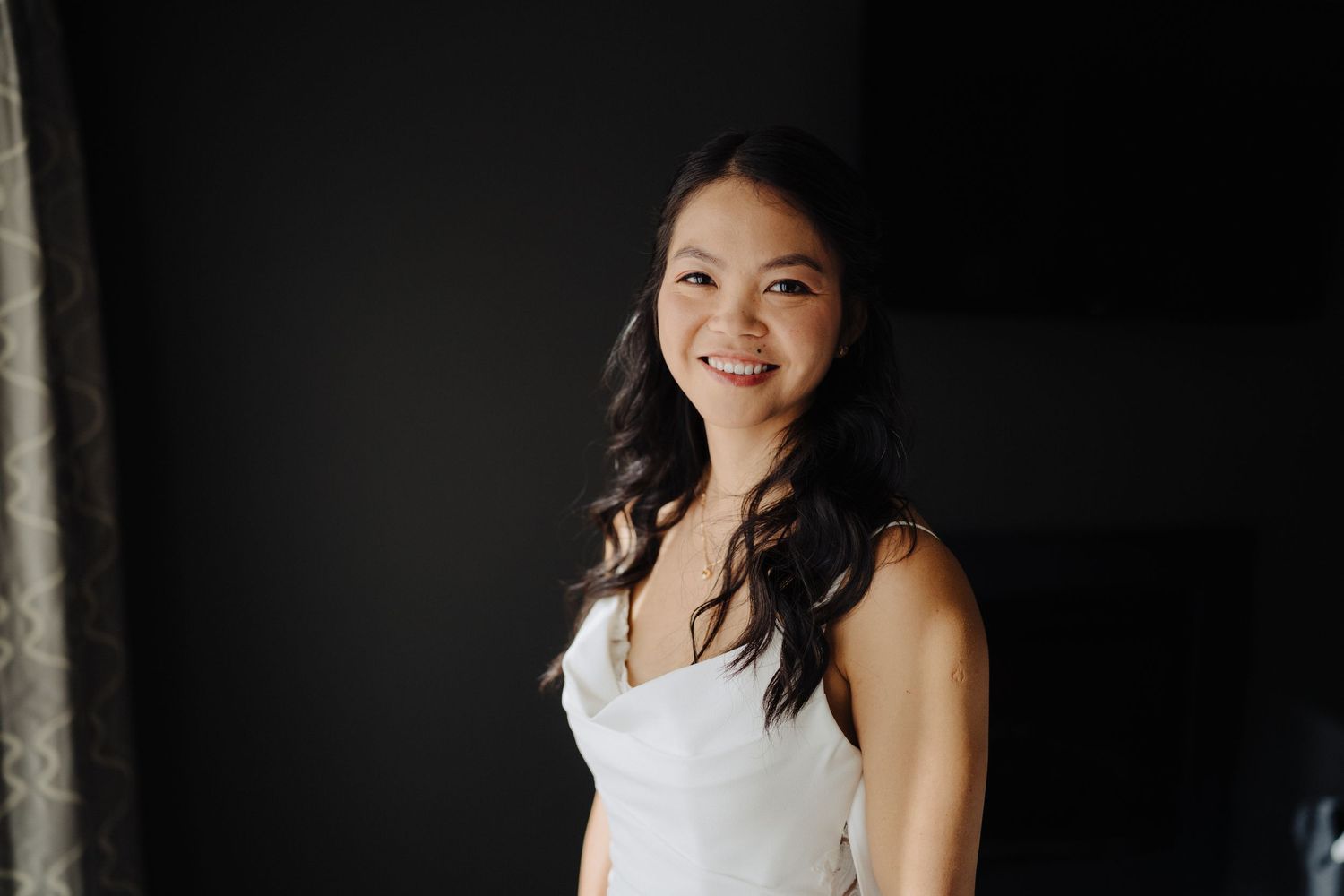 A set of four wedding portraits in elegant white dresses against dark backgrounds.