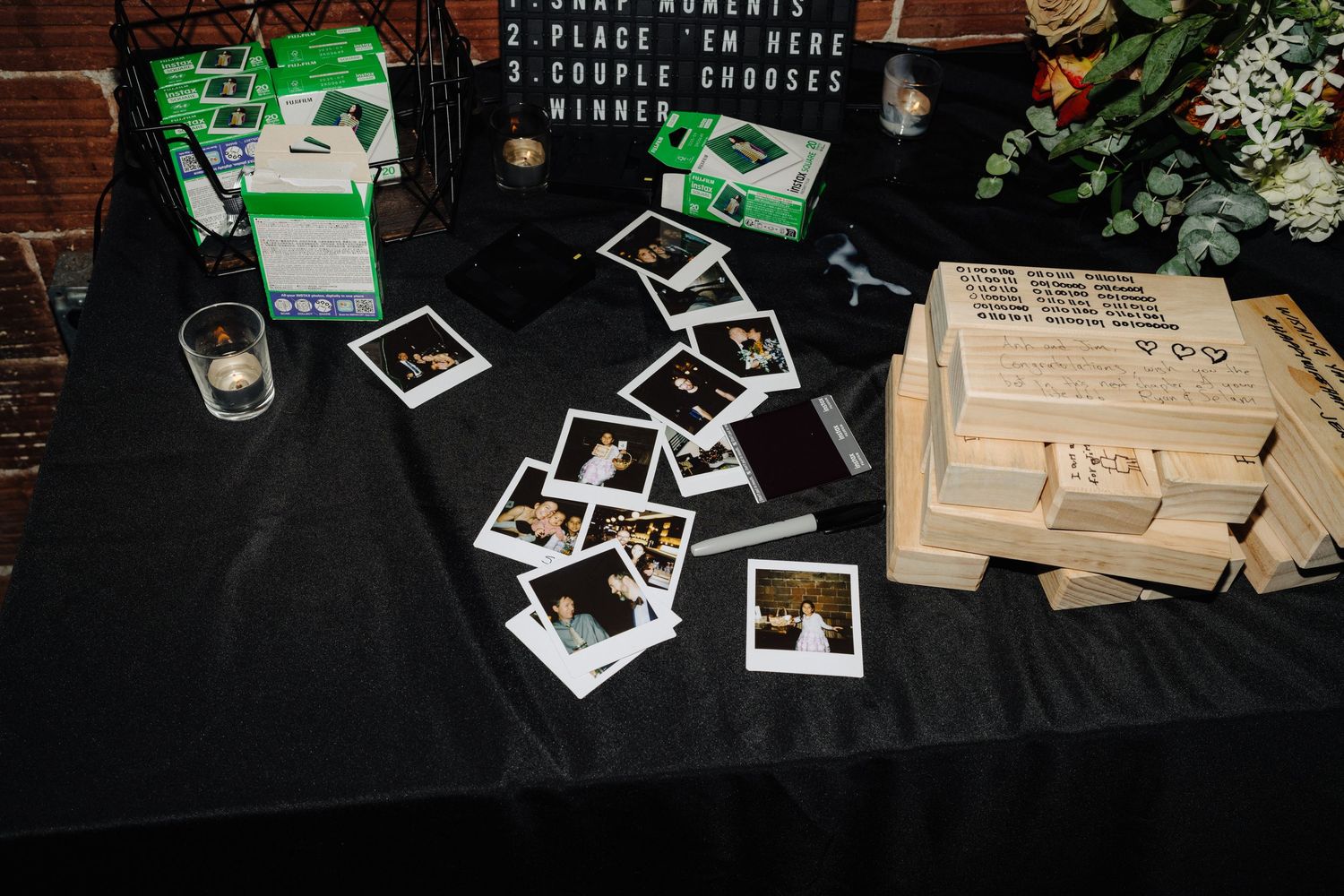 Collection of polaroid photos and memorabilia displayed on black tablecloth.
