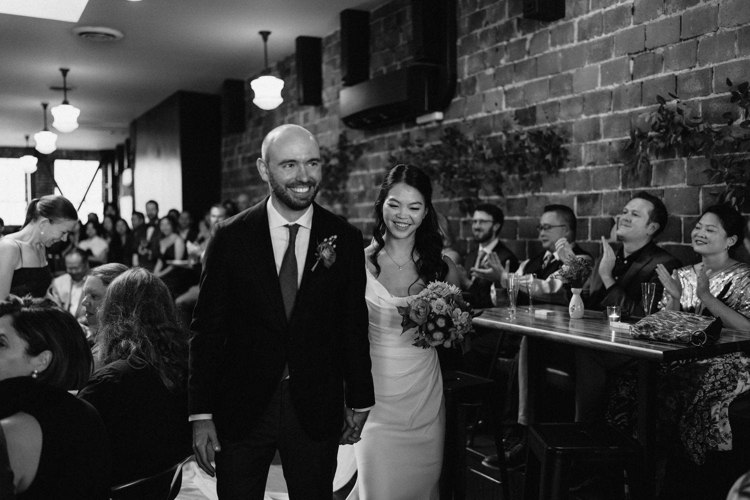 Wedding celebration in an industrial-style venue with exposed brick walls and vintage lighting fixtures.