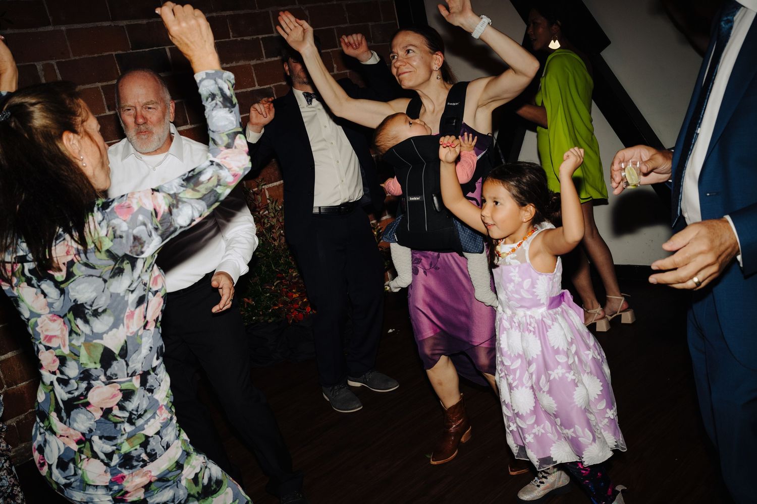 Wedding reception dance floor filled with guests dancing and celebrating.